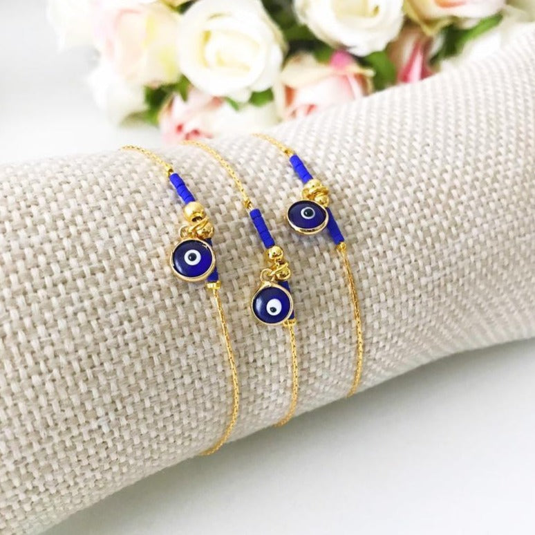 Minimal Evil Eye Bracelet featuring a blue glass charm and gold chain with tiny blue miyuki beads, elegantly designed for protection and style.