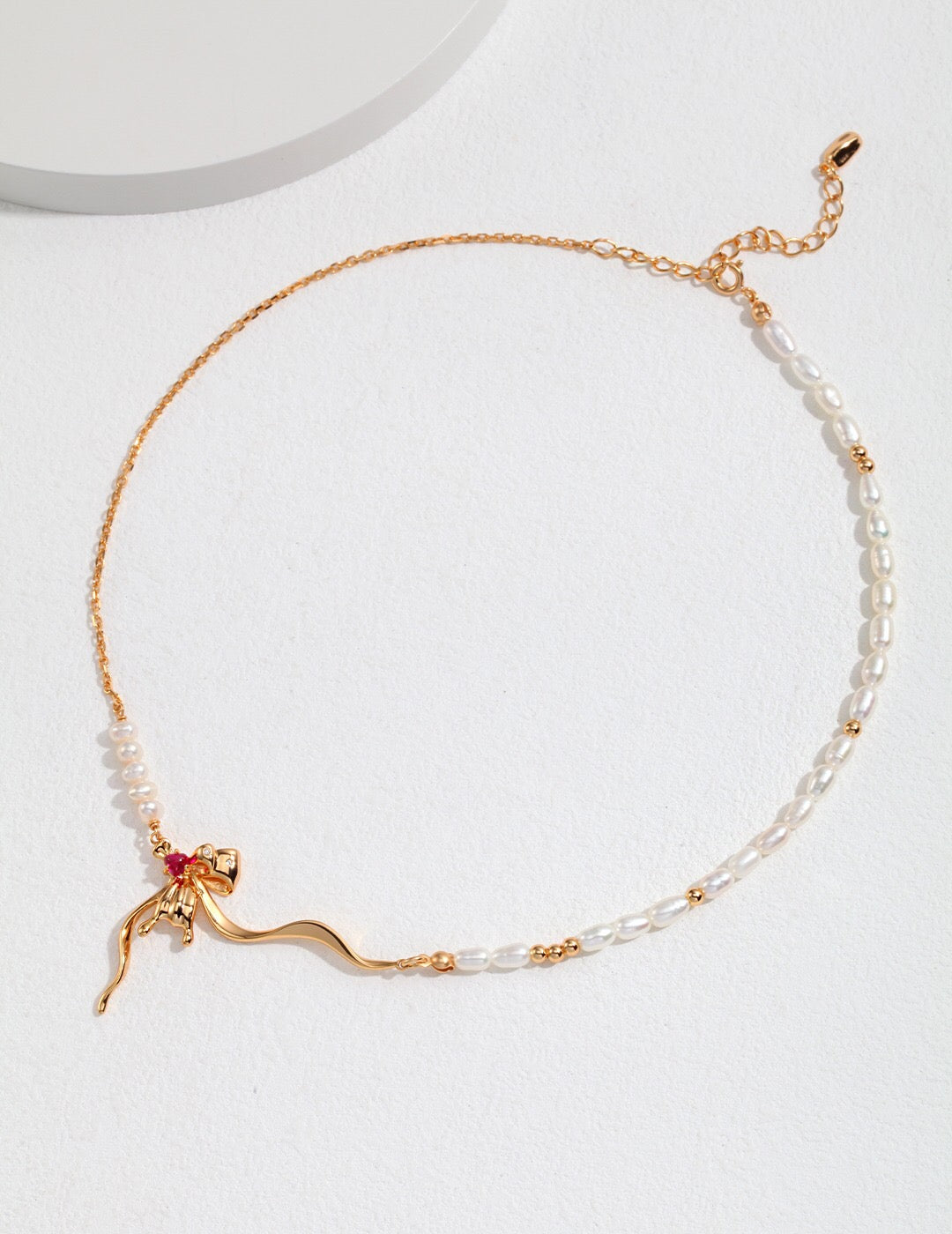 A delicate Minimalist Bow Pearl Necklace featuring freshwater pearls and gold vermeil accents, elegantly displayed on a soft background.