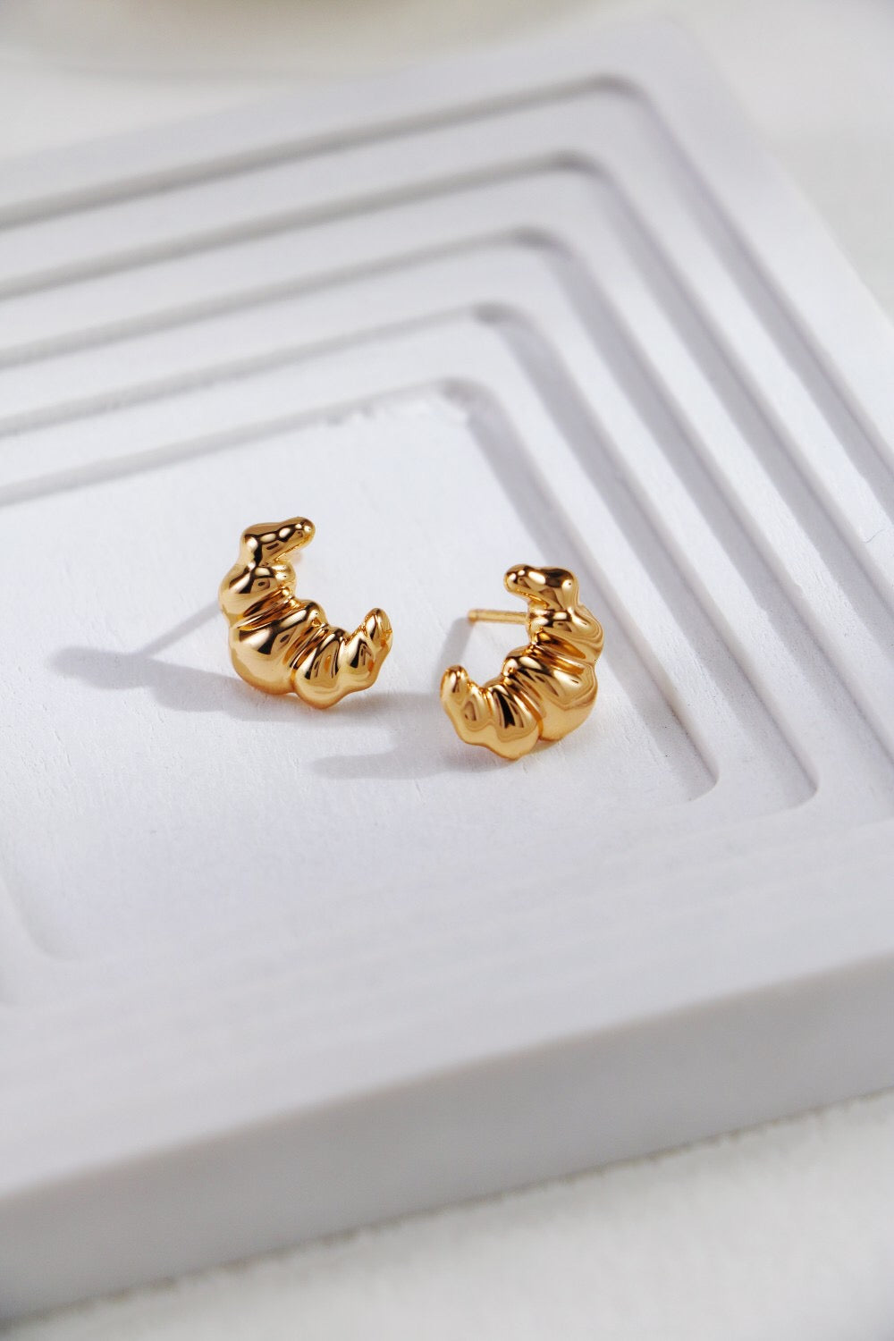 Minimalist Croissant Stud Earrings made of sterling silver and gold vermeil, showcasing a delicate croissant shape.