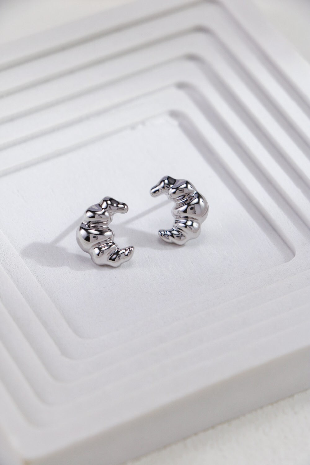 Minimalist Croissant Stud Earrings made of sterling silver and gold vermeil, showcasing a delicate croissant shape.