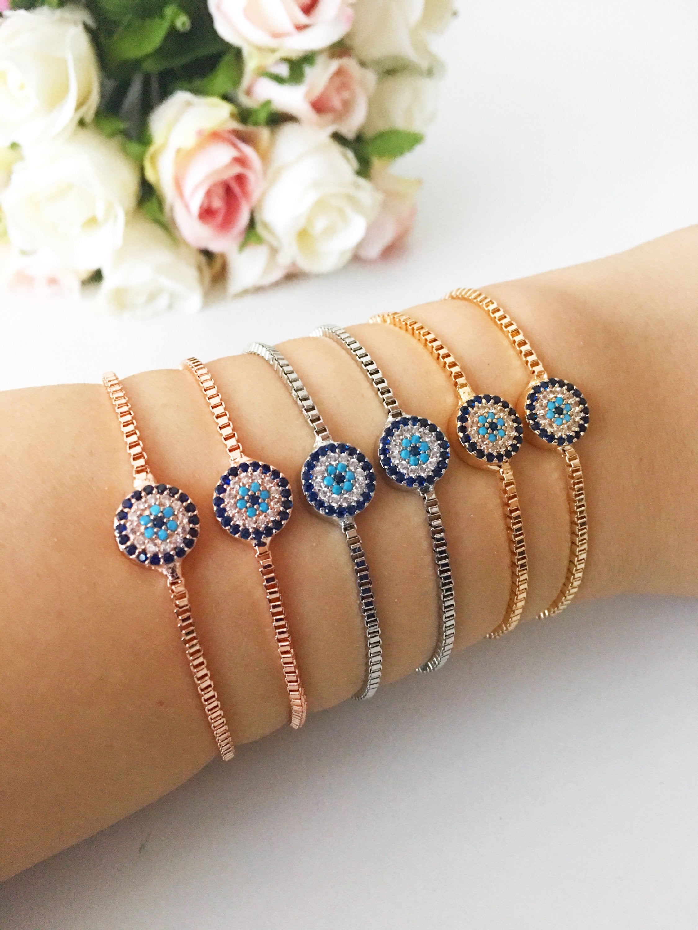 A stylish Minimalist Evil Eye Bracelet featuring an adjustable design in rose gold, silver, and gold with a sparkling evil eye charm.