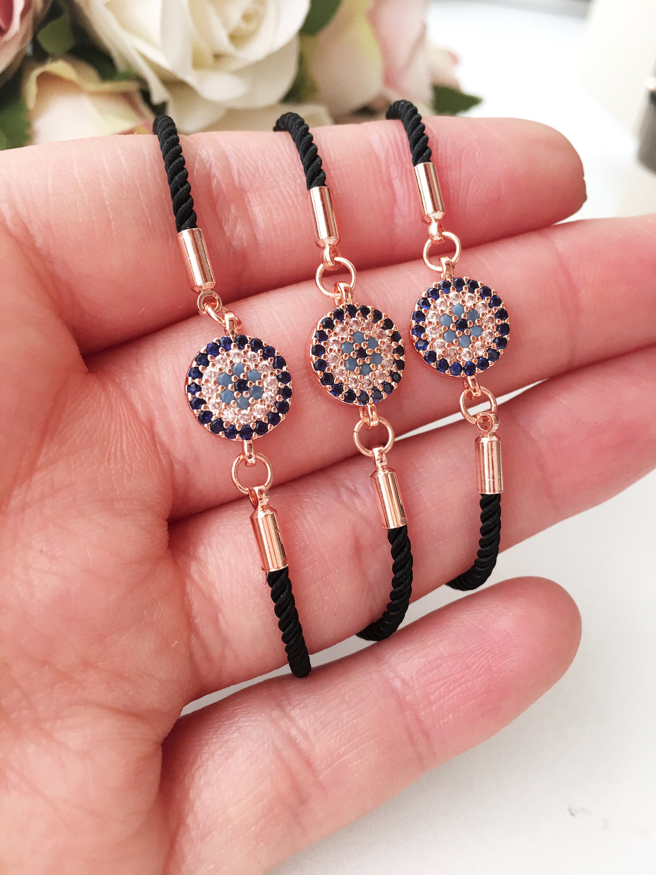 Minimalist Evil Eye Bracelet featuring an adjustable black string and a silver evil eye charm, showcasing its elegant design and craftsmanship.