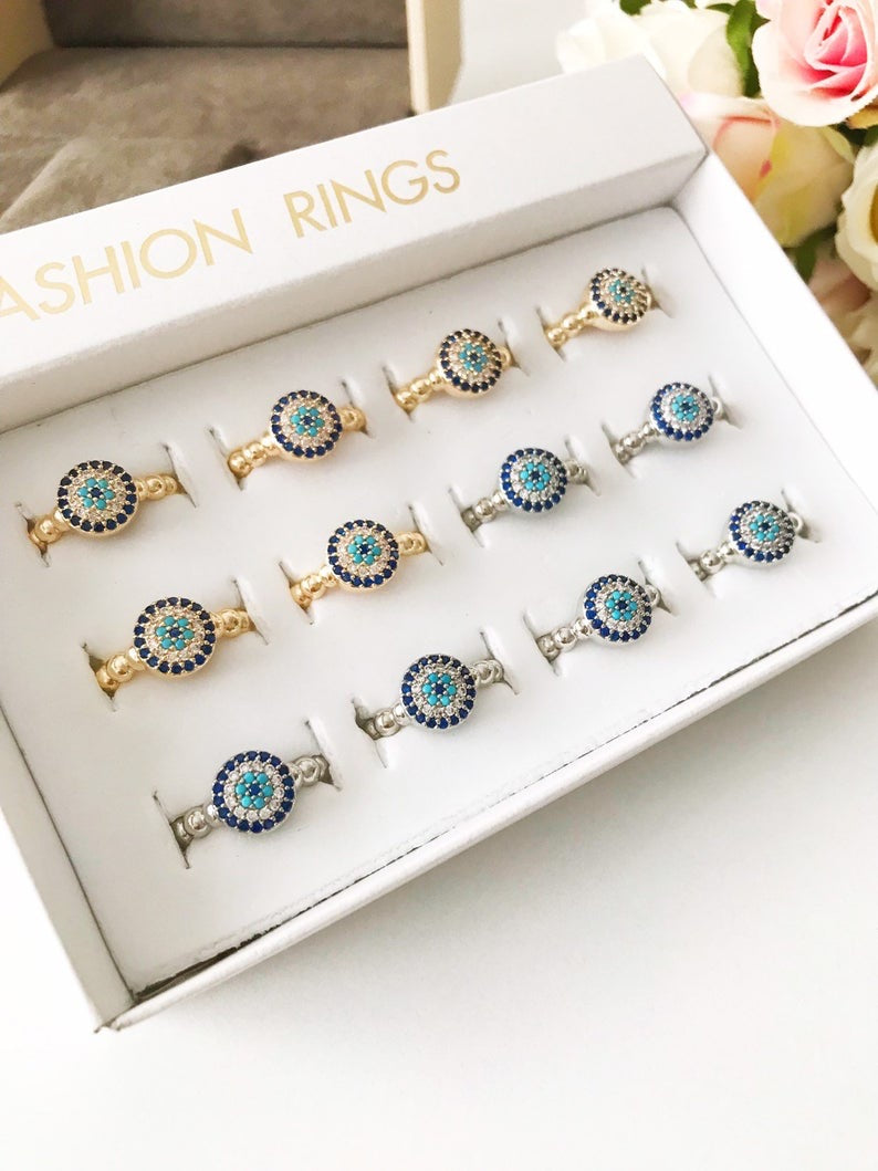 A stylish Minimalist Evil Eye Ring featuring a blue evil eye design with cubic zirconia accents, adjustable for all sizes, available in gold and silver.