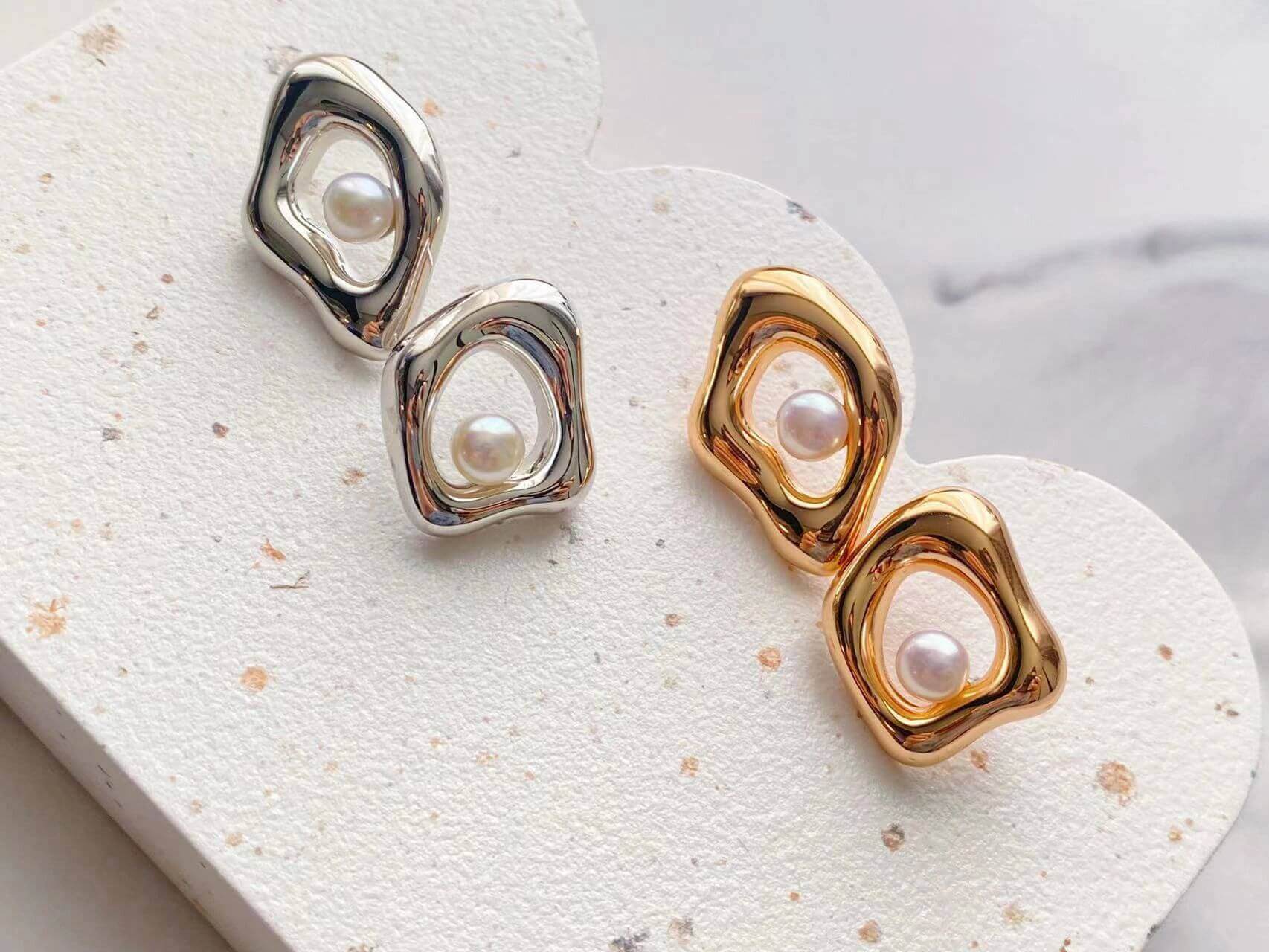 A pair of handmade minimalist geometric irregular earrings featuring natural pearls and sterling silver with gold vermeil plating.