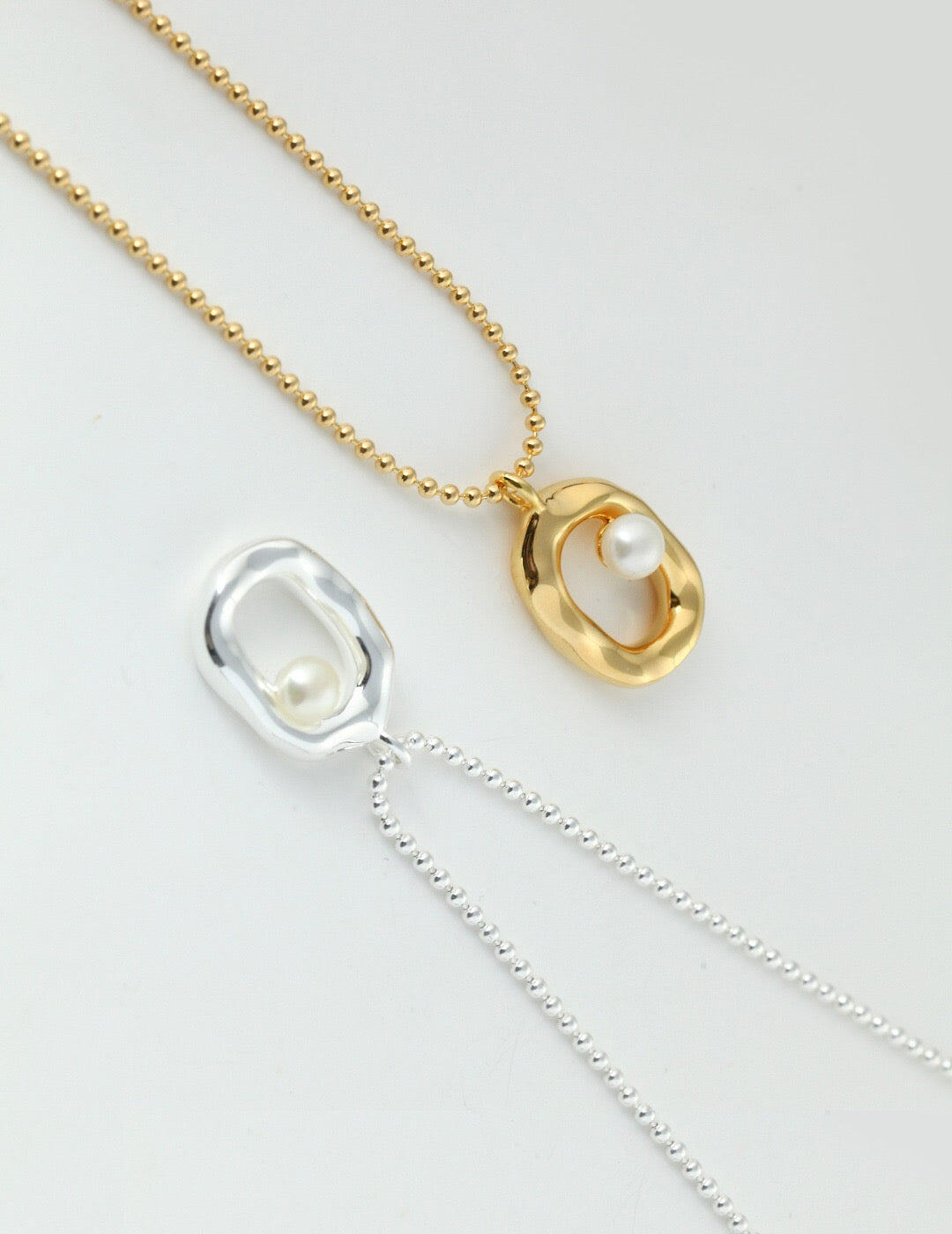 A beautiful Minimalist O-shaped Pearl Pendant Necklace featuring a natural pearl and gold vermeil, elegantly displayed on a soft background.