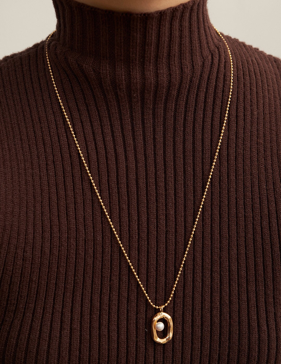 A beautiful Minimalist O-shaped Pearl Pendant Necklace featuring a natural pearl and gold vermeil, elegantly displayed on a soft background.