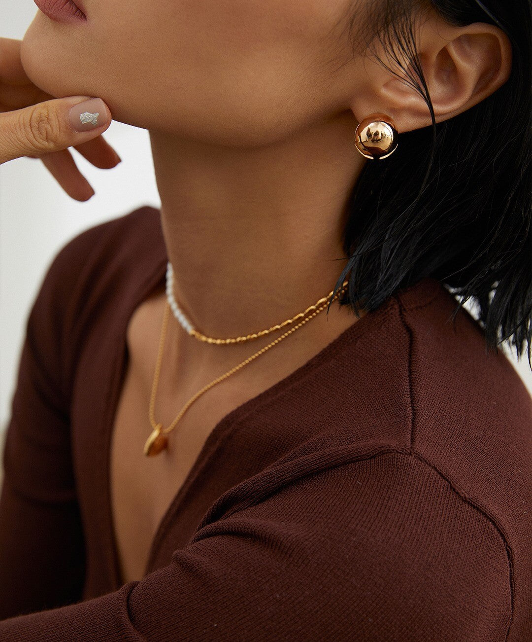 A delicate Minimalist Rice Bead Chain Asymmetric Necklace featuring natural pearls and sterling silver, elegantly displayed on a soft background.