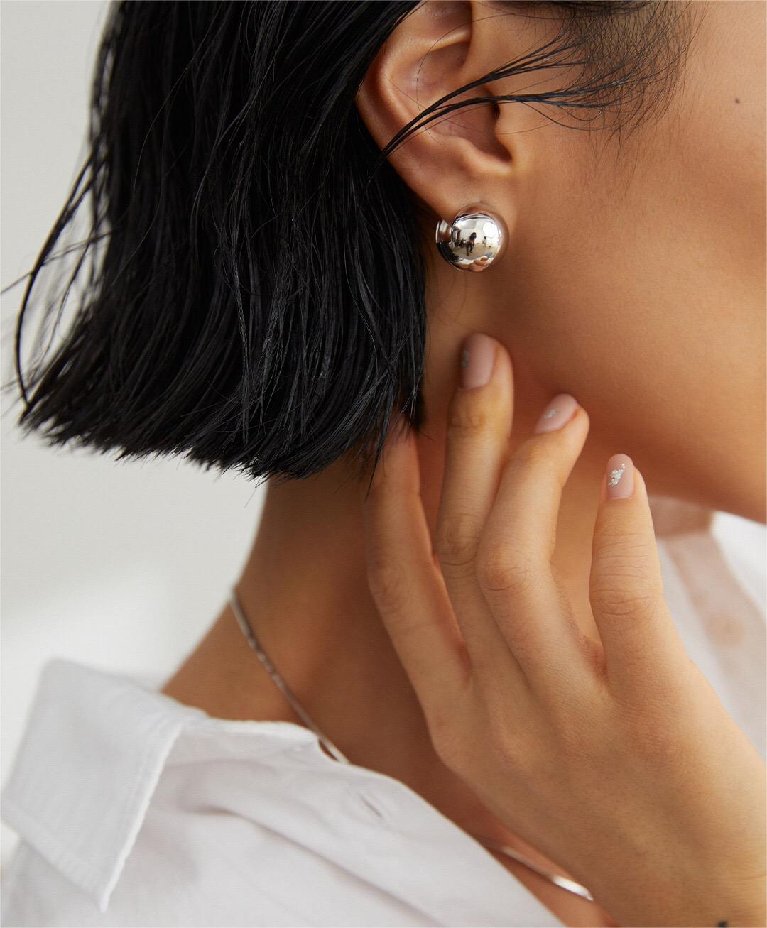 A pair of elegant Minimalist Round Ball Earrings made from sterling silver and gold vermeil, showcasing their shiny, round design.