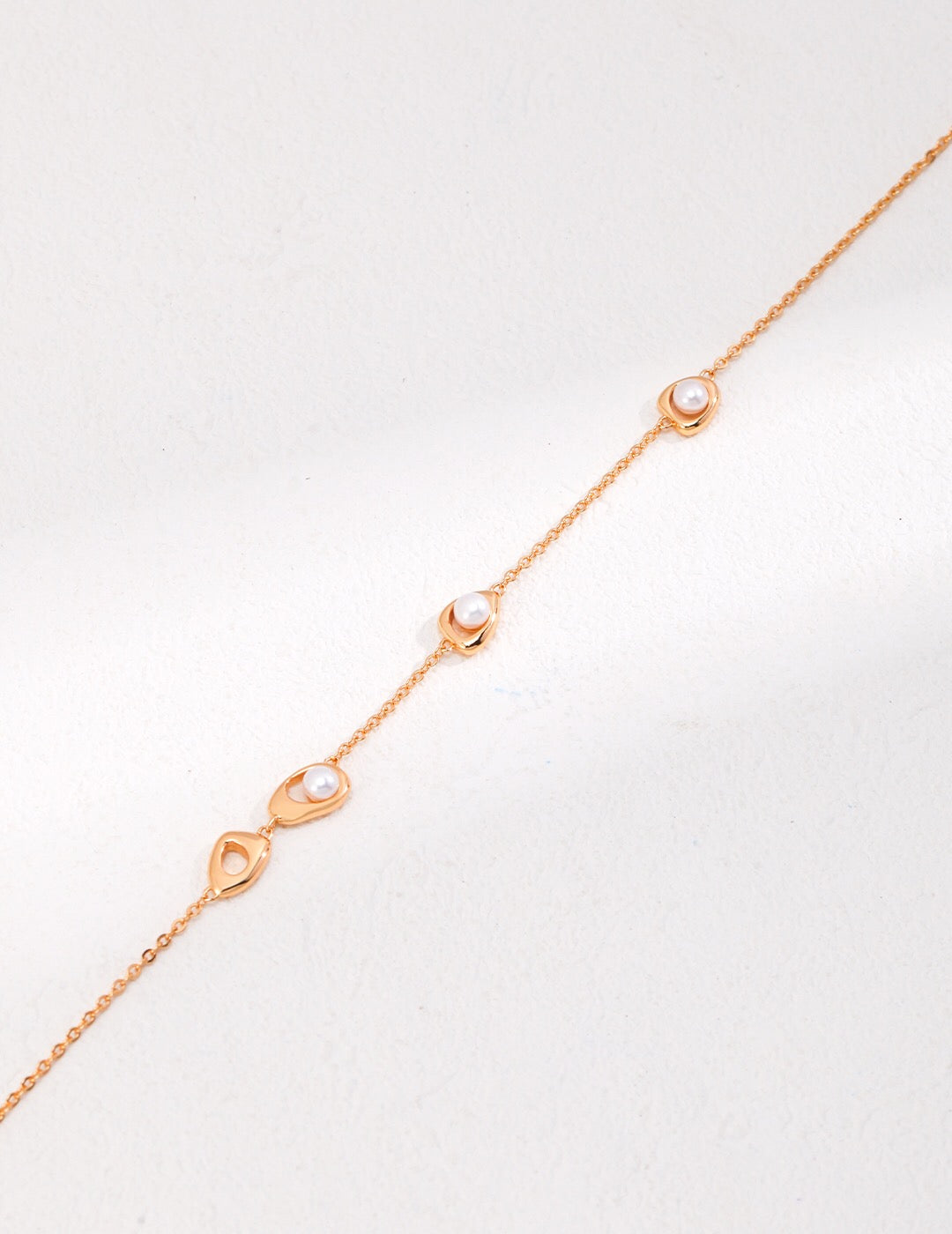 A delicate Minimalist Three Pearl Beads Necklace featuring three natural pearls on a gold vermeil chain, elegantly displayed on a soft background.