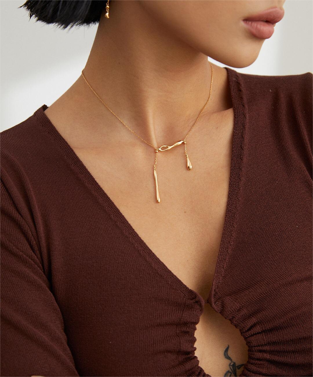 A delicate Minimalist Water Droplets Style Necklace made of sterling silver with a gold vermeil finish, showcasing a unique water droplet design.