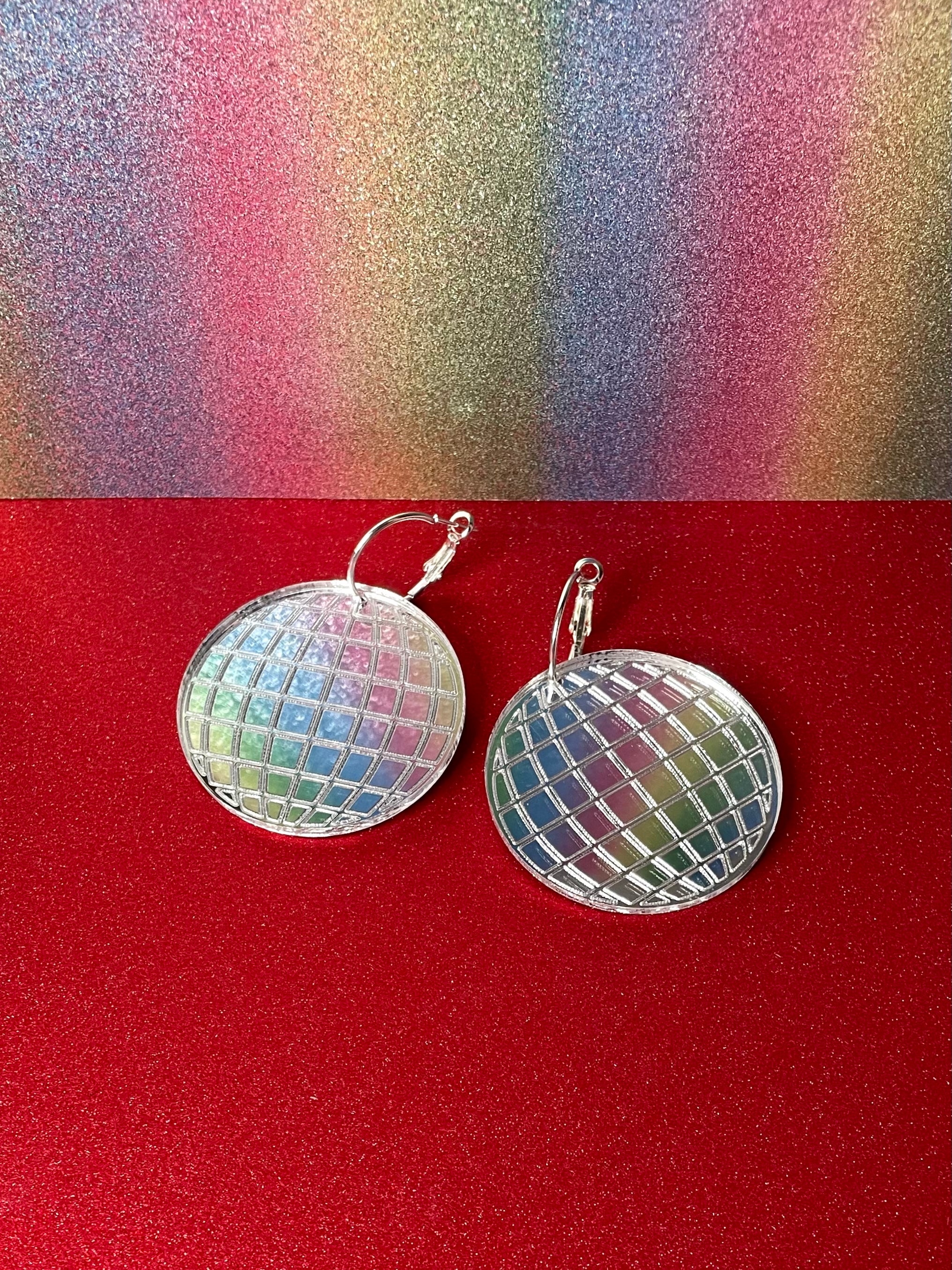 A pair of dazzling Mirror Ball Earrings featuring colorful mirror finishes, available as dangles or studs, showcasing their unique design.