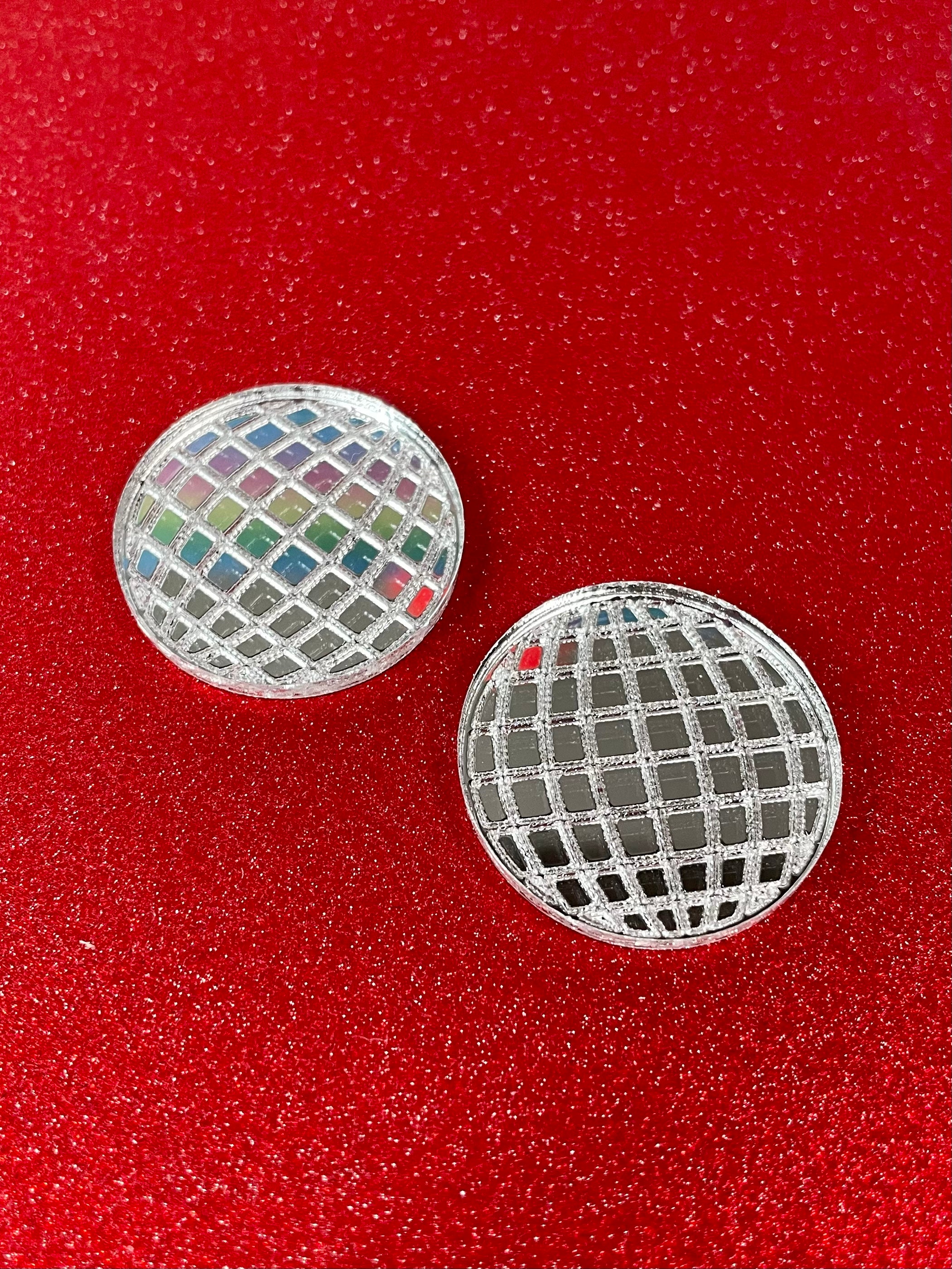 A pair of dazzling Mirror Ball Earrings featuring colorful mirror finishes, available as dangles or studs, showcasing their unique design.