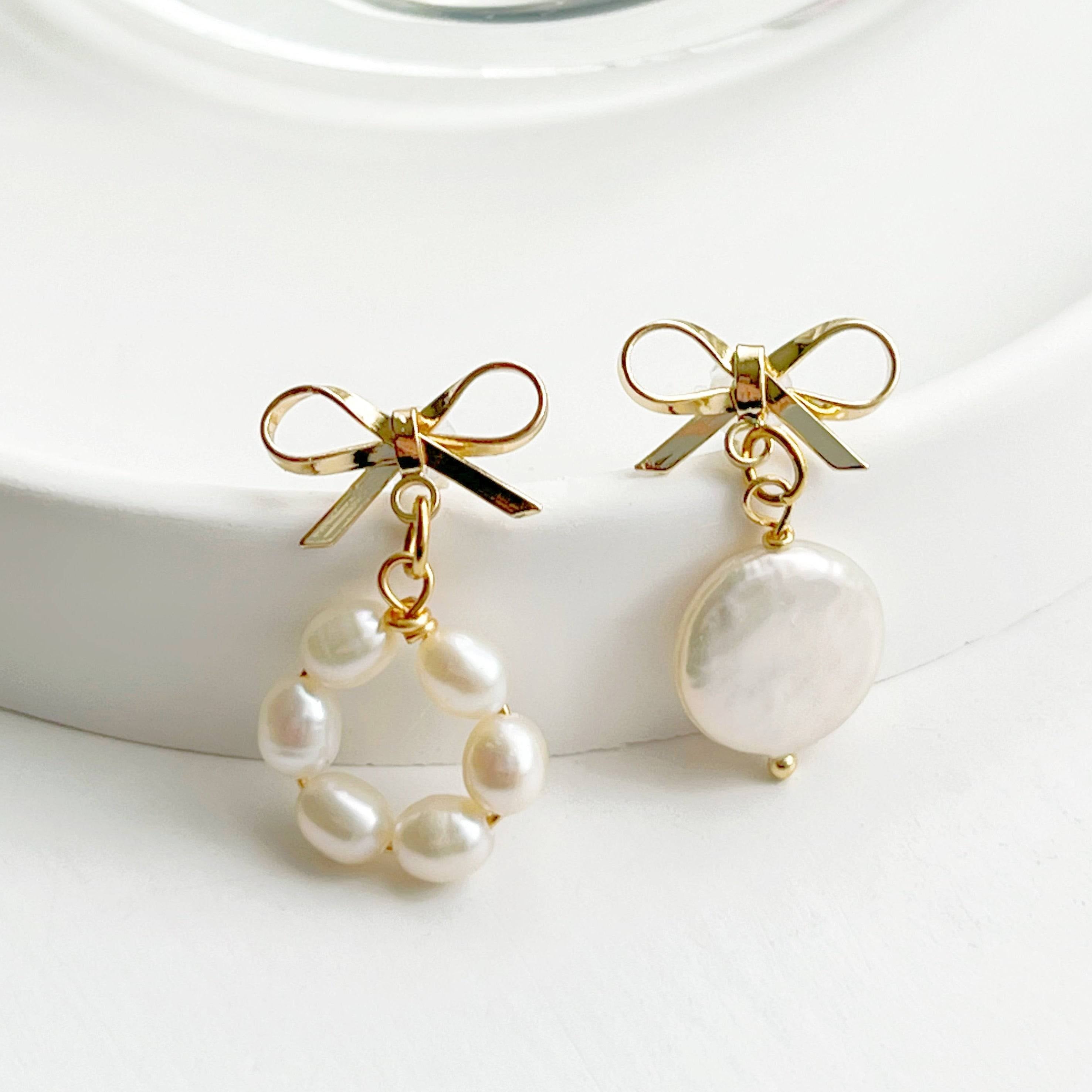 A pair of handmade mismatched baroque pearl earrings featuring unique freshwater pearls and gold-plated studs, elegantly displayed.