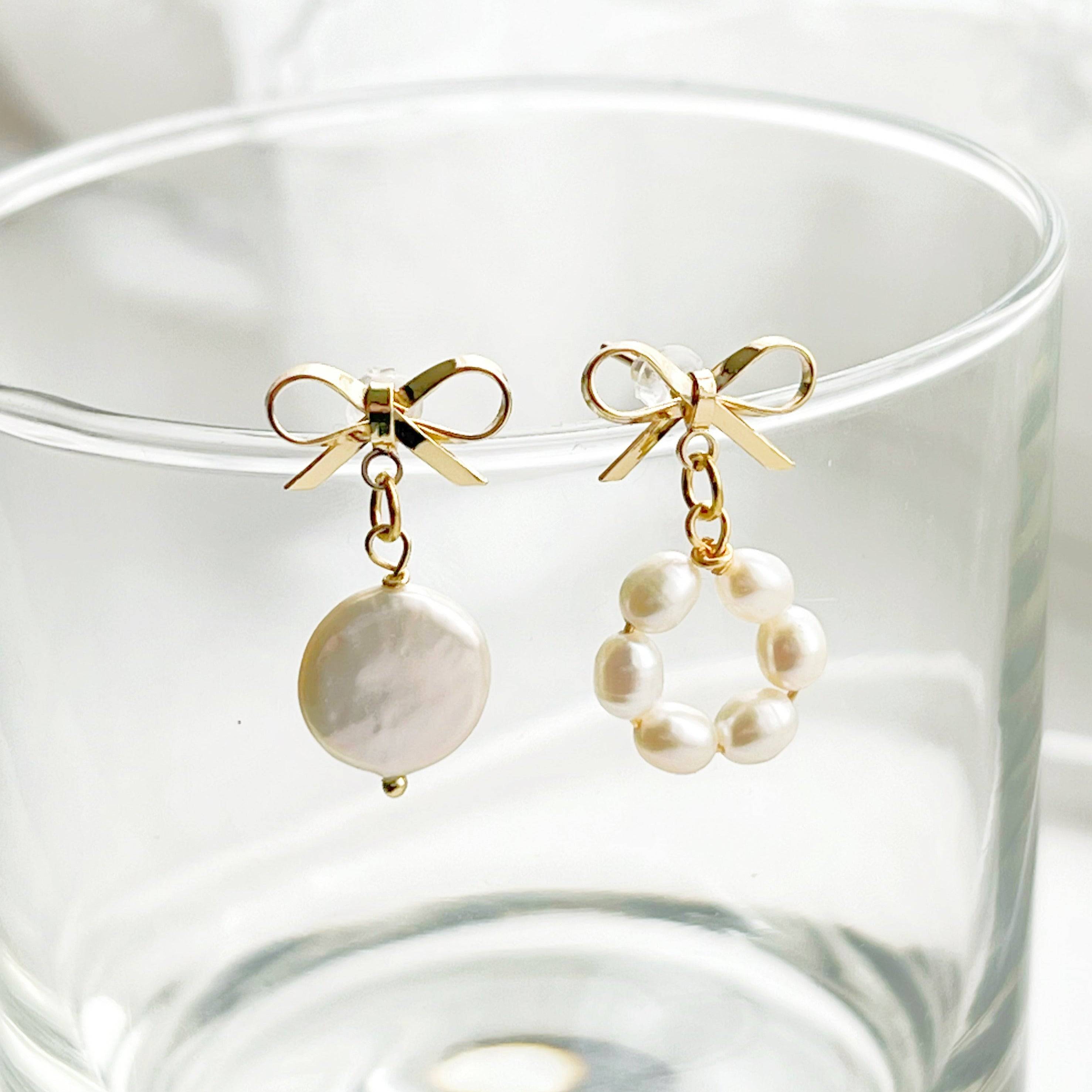 A pair of handmade mismatched baroque pearl earrings featuring unique freshwater pearls and gold-plated studs, elegantly displayed.