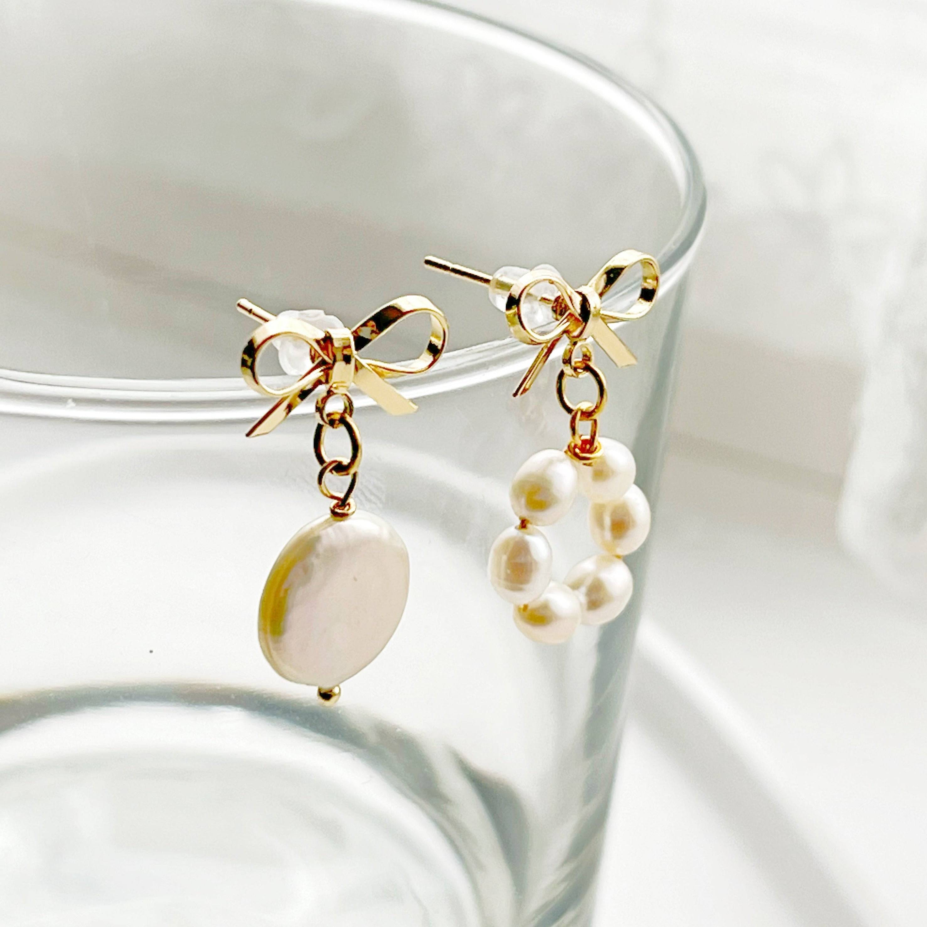 A pair of handmade mismatched baroque pearl earrings featuring unique freshwater pearls and gold-plated studs, elegantly displayed.