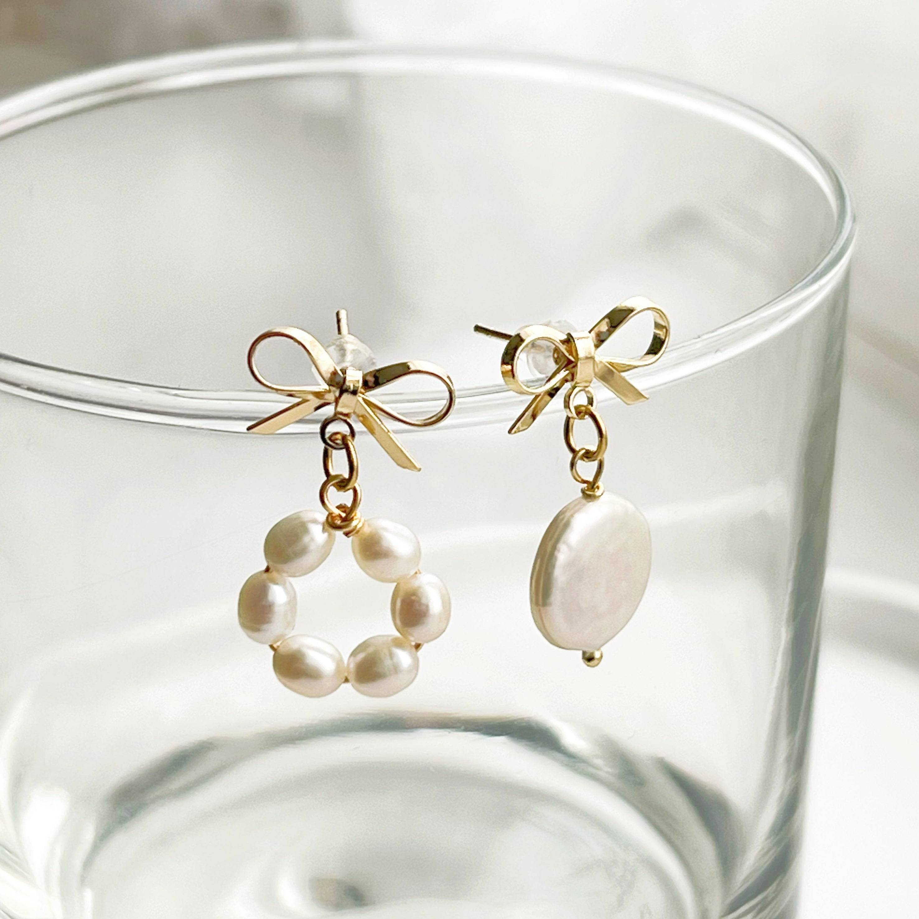 A pair of handmade mismatched baroque pearl earrings featuring unique freshwater pearls and gold-plated studs, elegantly displayed.