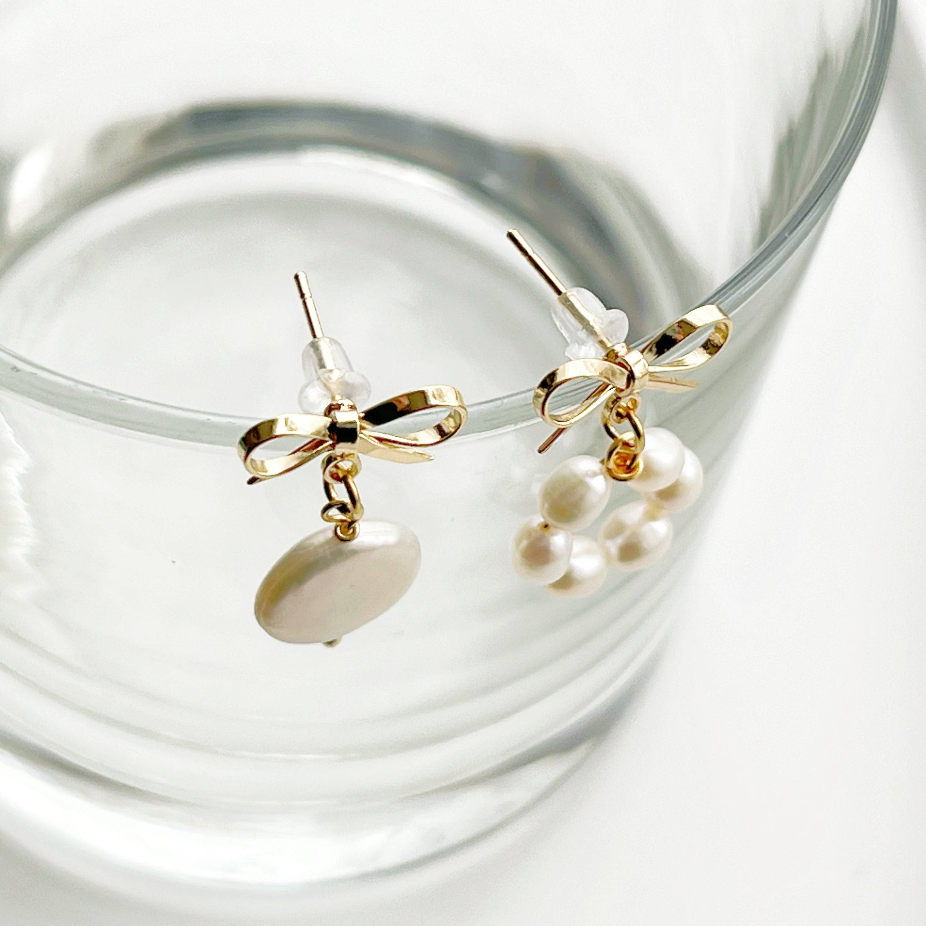 A pair of handmade mismatched baroque pearl earrings featuring unique freshwater pearls and gold-plated studs, elegantly displayed.