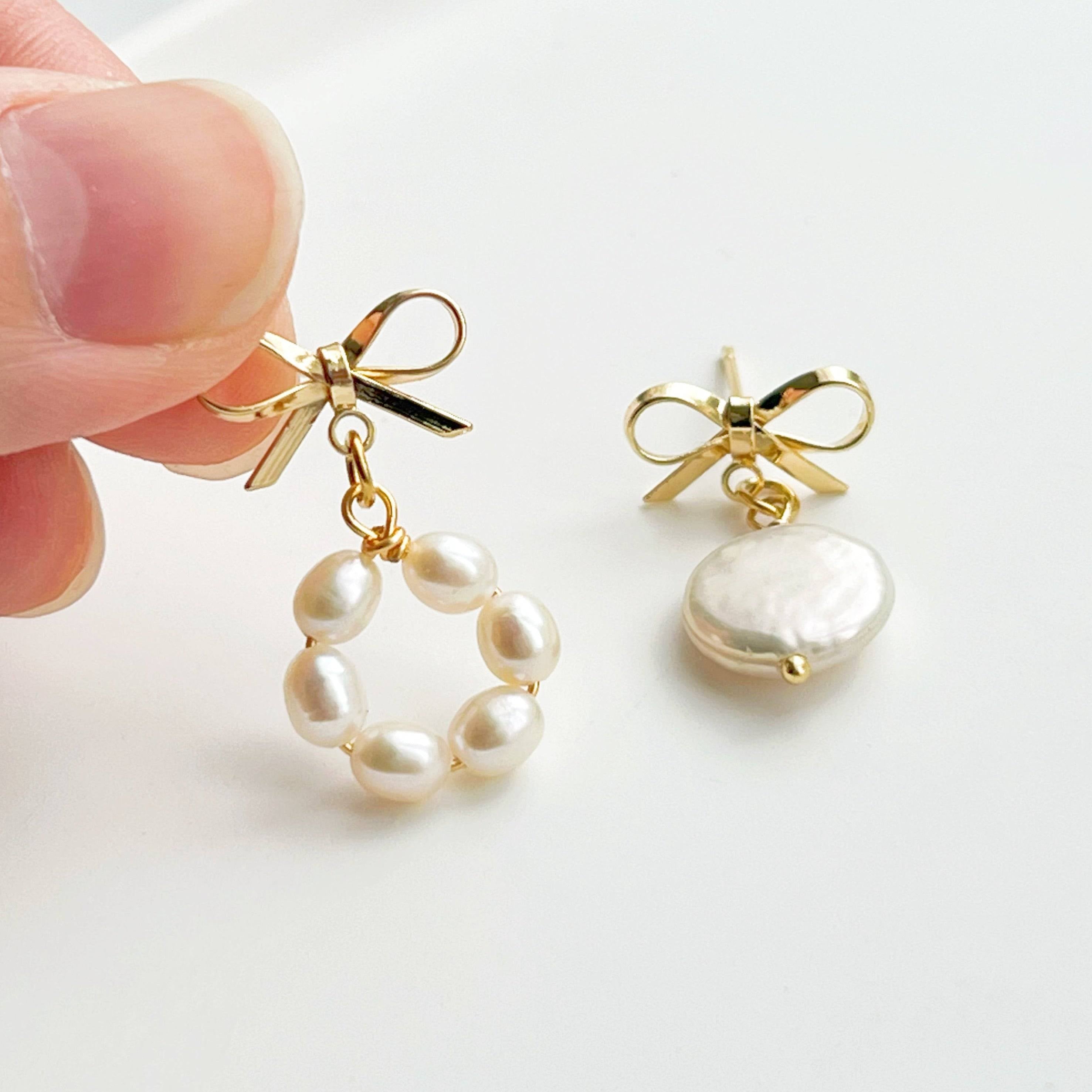 A pair of handmade mismatched baroque pearl earrings featuring unique freshwater pearls and gold-plated studs, elegantly displayed.