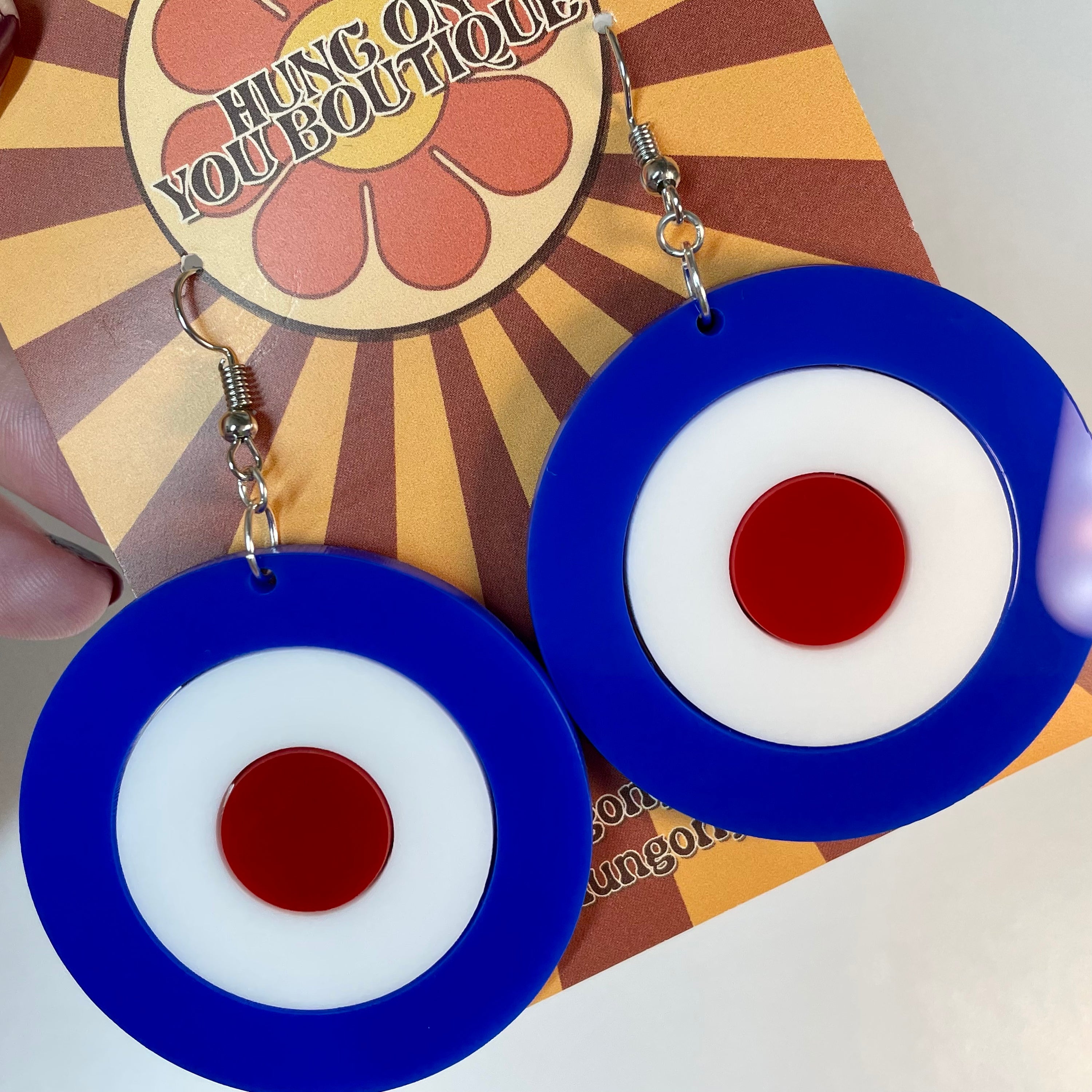 A pair of stylish Mod Target Earrings featuring laser-cut acrylic in a vibrant design, available in silver or gold finishes.