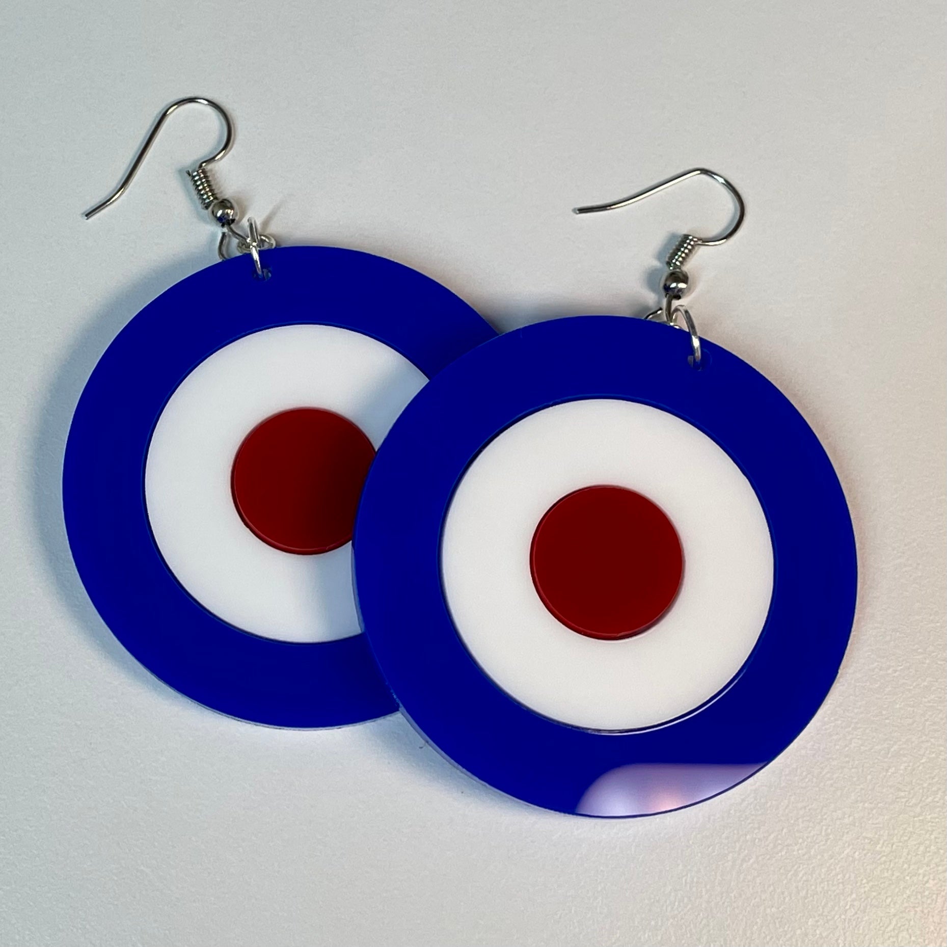 A pair of stylish Mod Target Earrings featuring laser-cut acrylic in a vibrant design, available in silver or gold finishes.