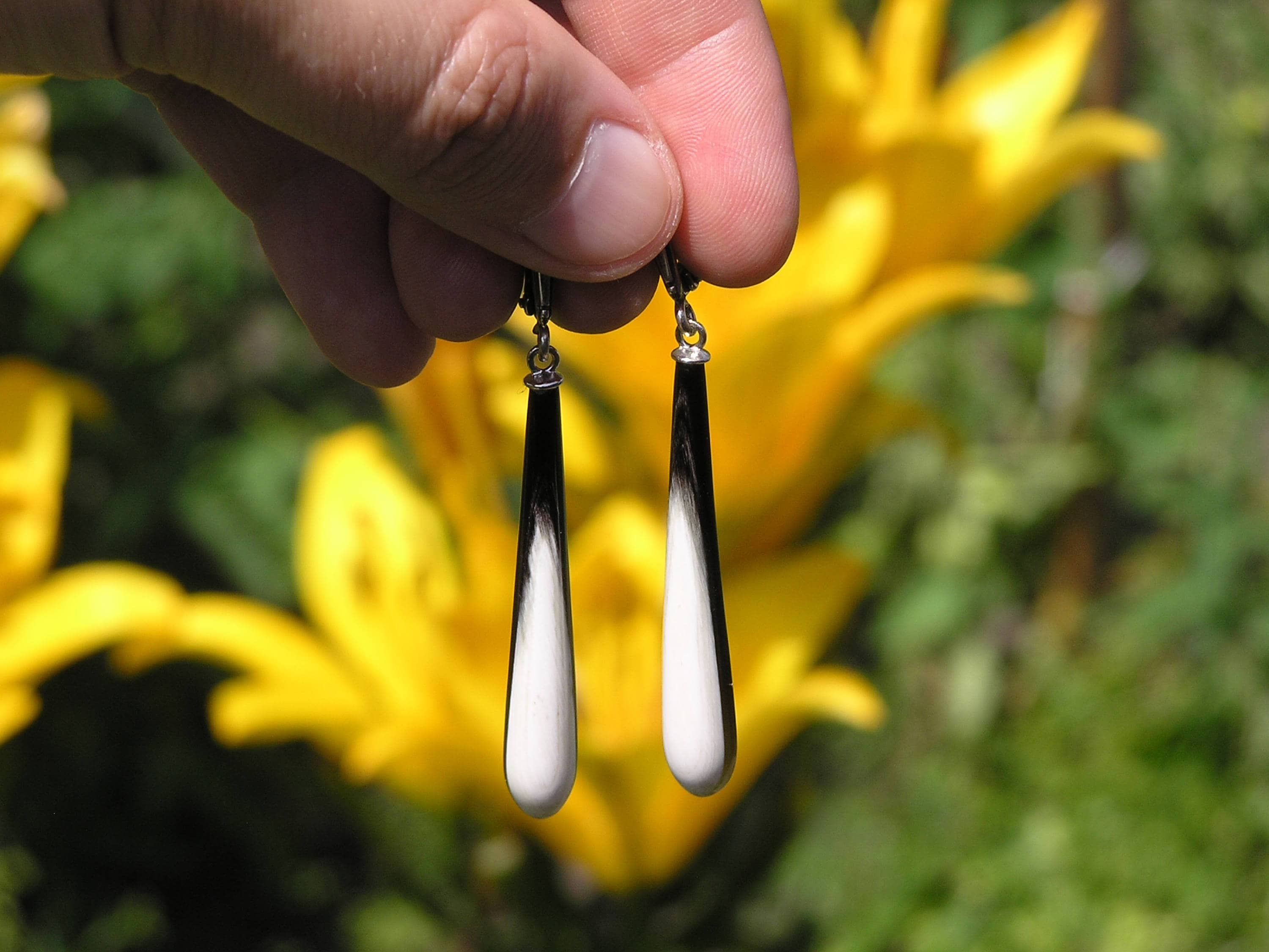 A pair of exclusive handmade modern statement earrings crafted from natural horn, featuring a luxurious design with a smooth surface and silver English locks.