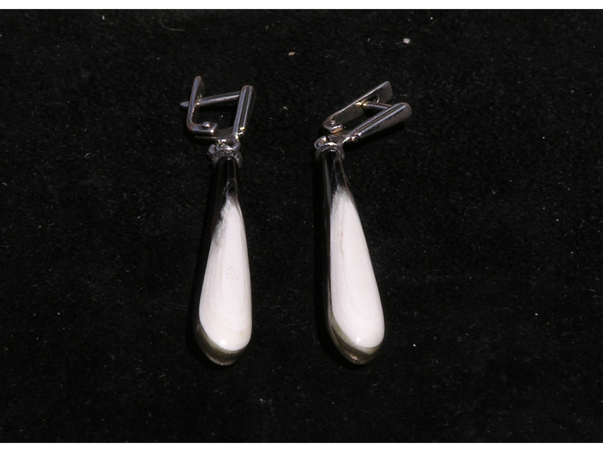 A pair of exclusive handmade modern statement earrings crafted from natural horn, featuring a luxurious design with a smooth surface and silver English locks.