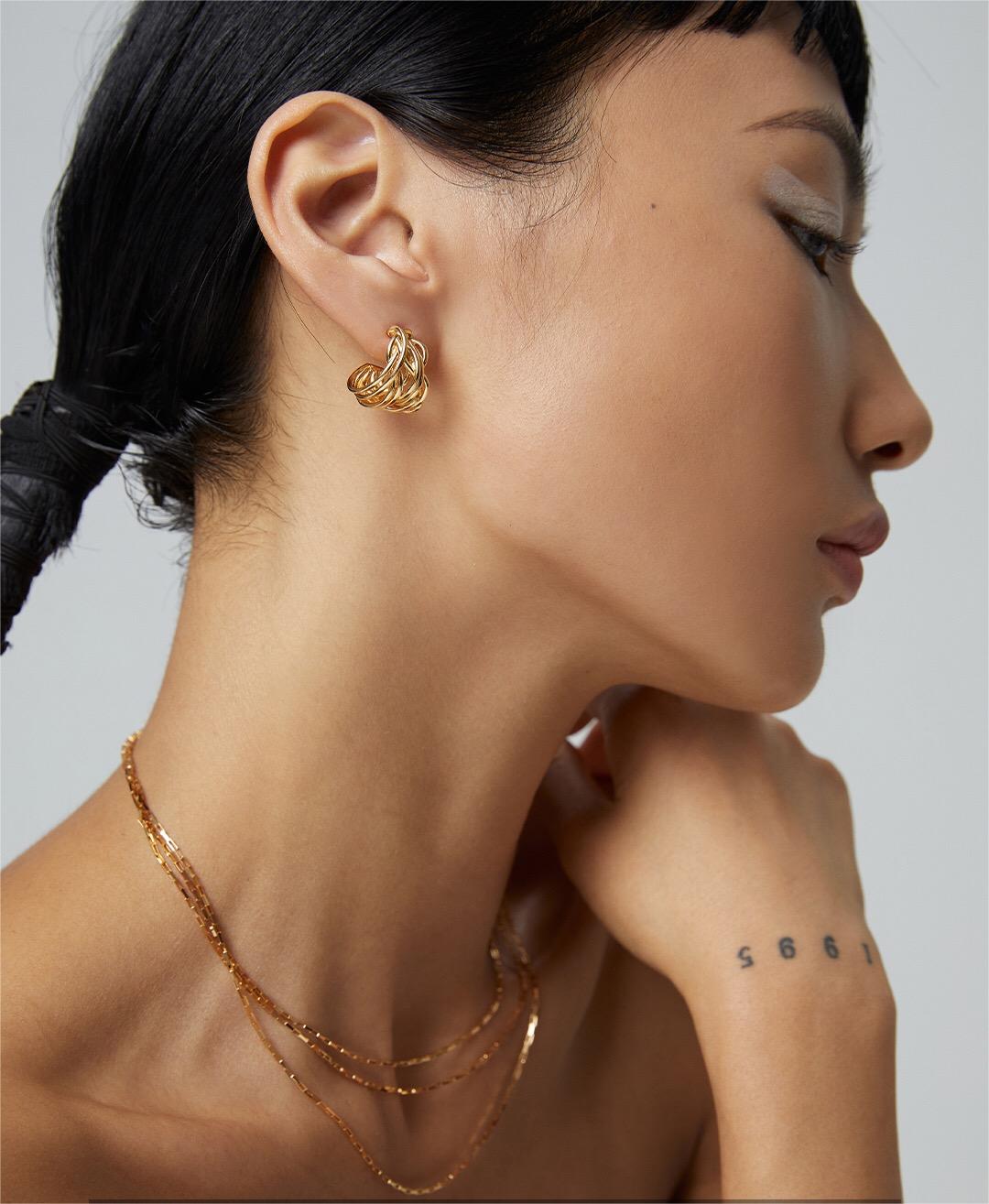 A pair of Modern Wave Hoop Earrings made from sterling silver and gold vermeil, showcasing a unique wave design.