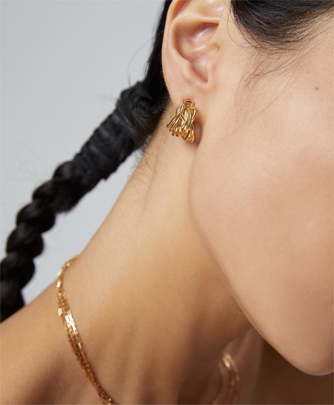 A pair of Modern Wave Hoop Earrings made from sterling silver and gold vermeil, showcasing a unique wave design.