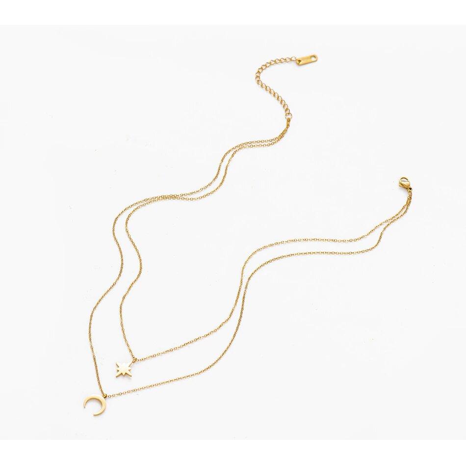 A dainty layered necklace featuring a moon and star design, crafted from 14k gold plated brass, elegantly displayed in a gift box.