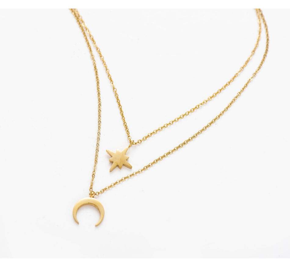 A dainty layered necklace featuring a moon and star design, crafted from 14k gold plated brass, elegantly displayed in a gift box.