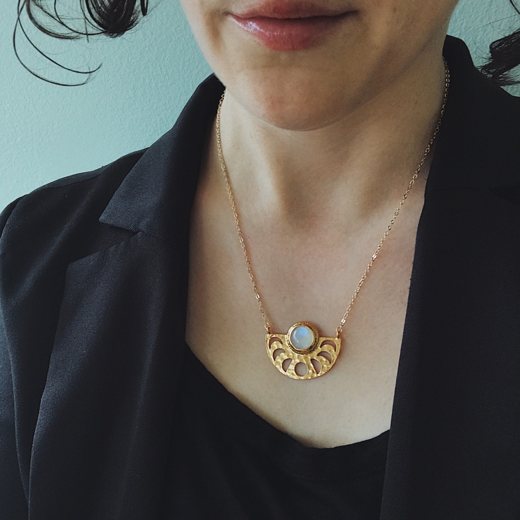 Moon Goddess Necklace featuring a gold tone raw brass pendant with phases of the Moon and a rainbow Moonstone centerpiece.