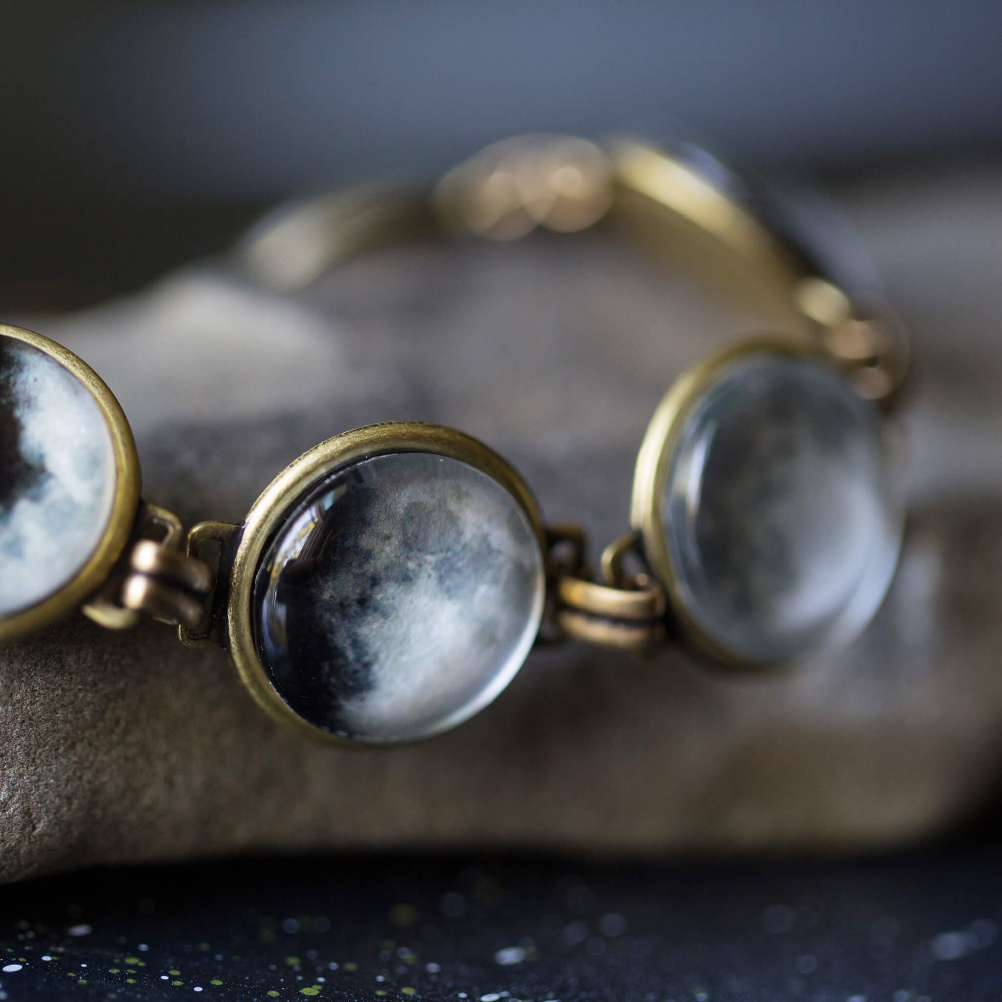 Moon Phase Bracelet showcasing seven lunar phases in antique silver and bronze finishes, handcrafted with plated brass and glass.