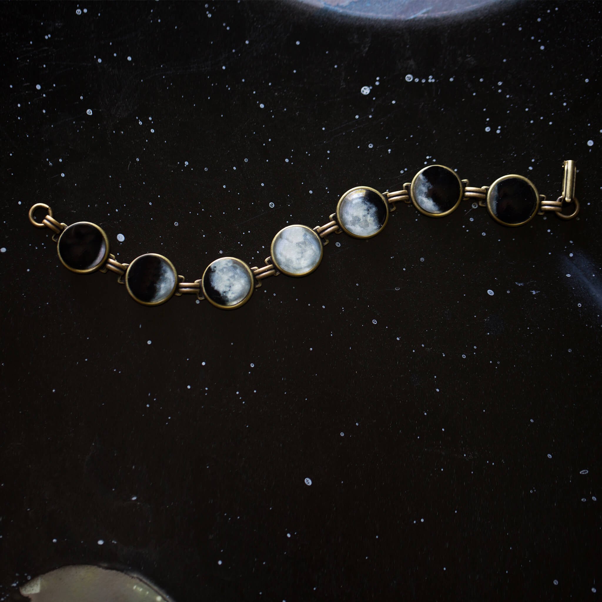 Moon Phase Bracelet showcasing seven lunar phases in antique silver and bronze finishes, handcrafted with plated brass and glass.