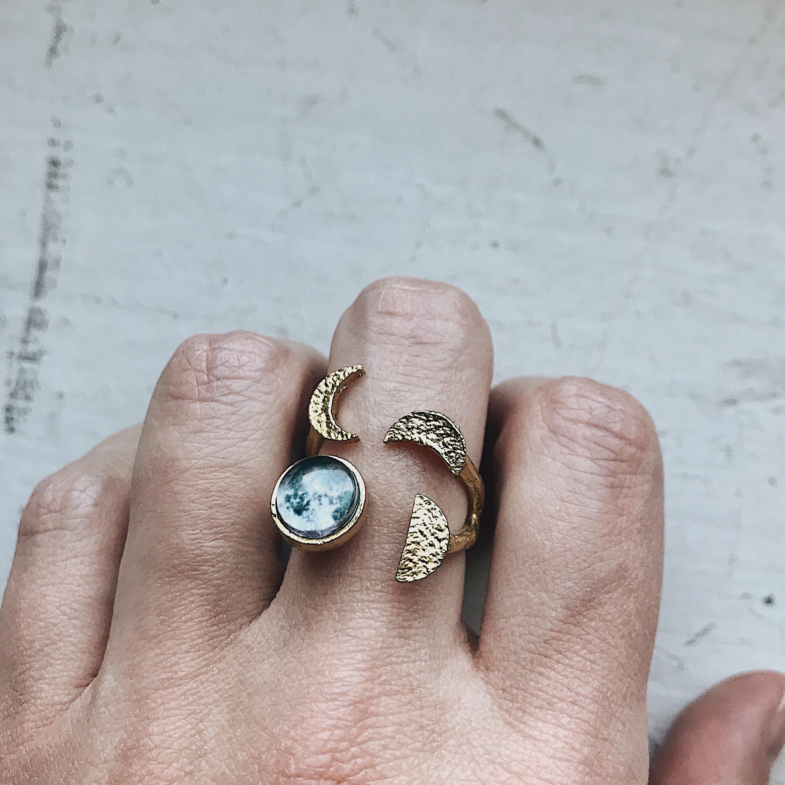 Moon Phase Sculpture Ring featuring hammered design with glass moon phases in silver and gold tones, adjustable size for comfort.