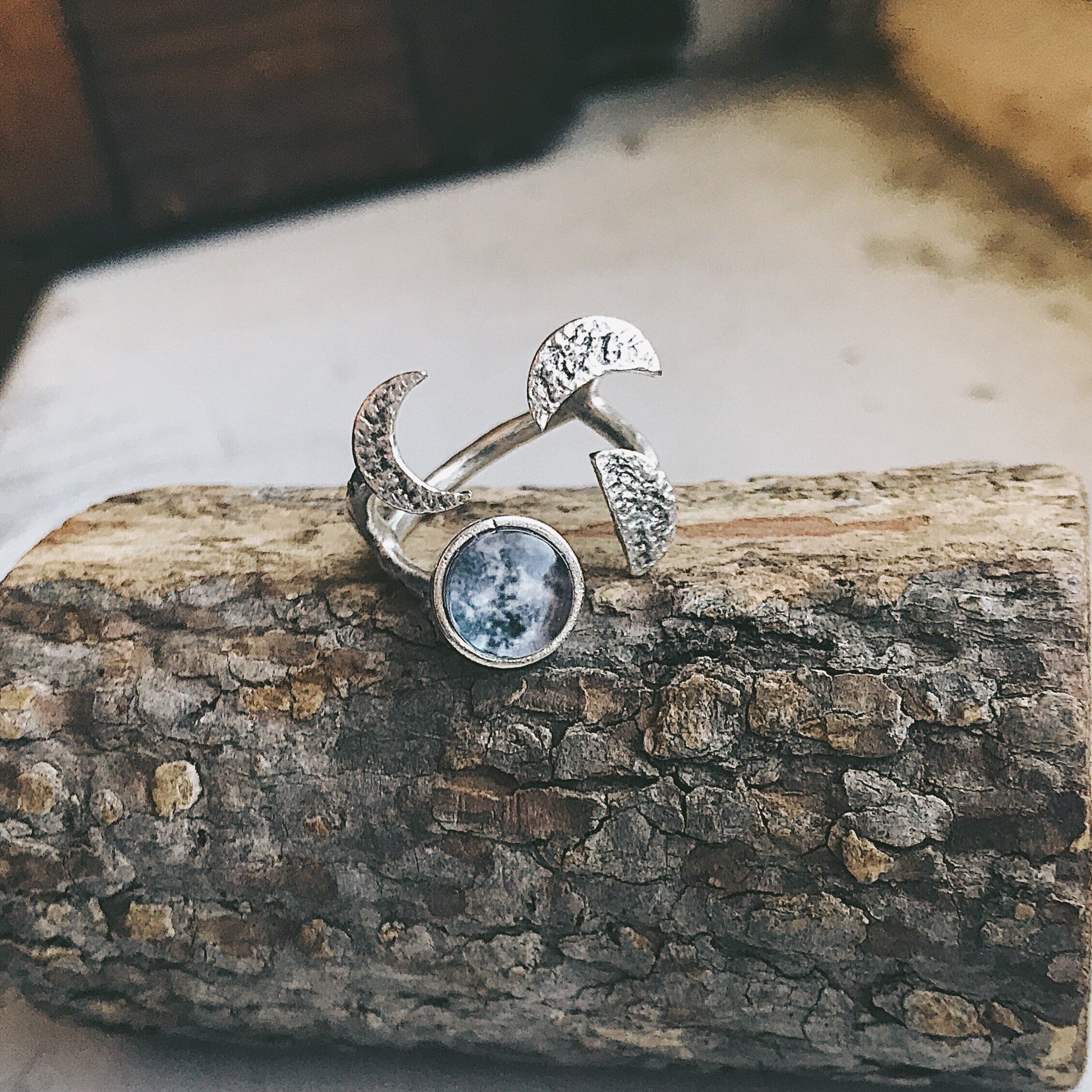 Moon Phase Sculpture Ring featuring hammered design with glass moon phases in silver and gold tones, adjustable size for comfort.