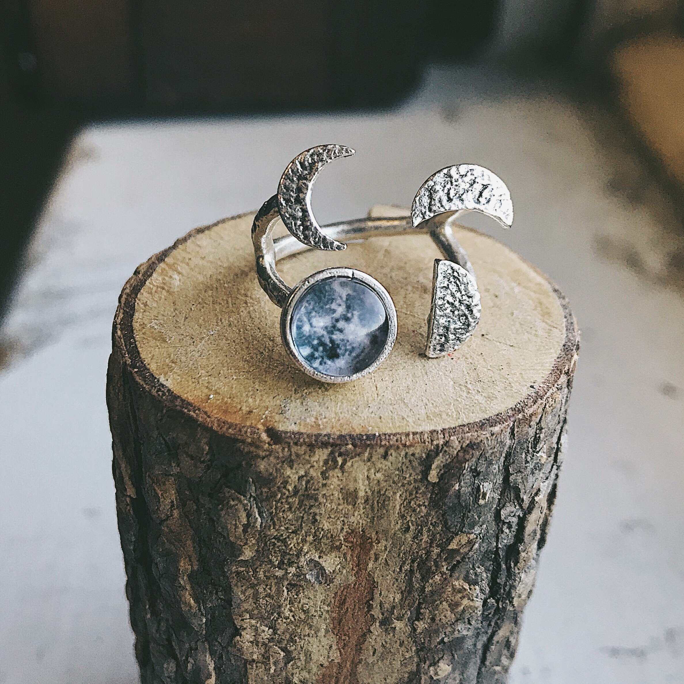 Moon Phase Sculpture Ring featuring hammered design with glass moon phases in silver and gold tones, adjustable size for comfort.