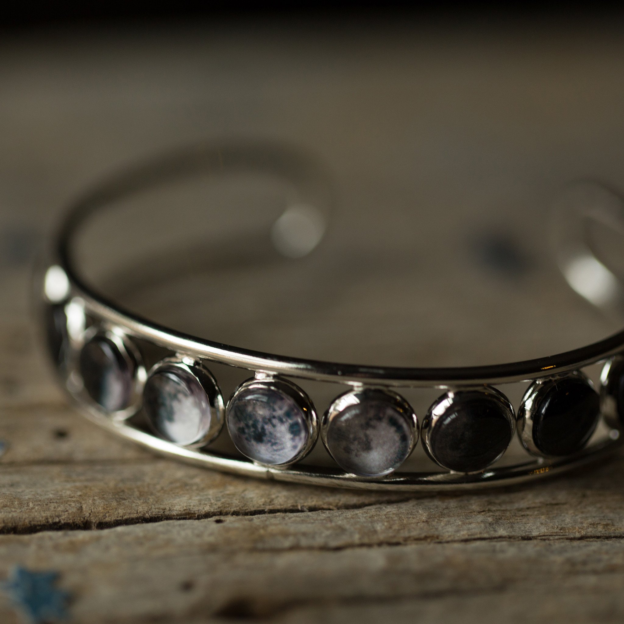 Moon Phase Silver Cuff Bracelet showcasing 9 lunar phases on an adjustable cuff, handcrafted with rhodium plated brass and glass accents.