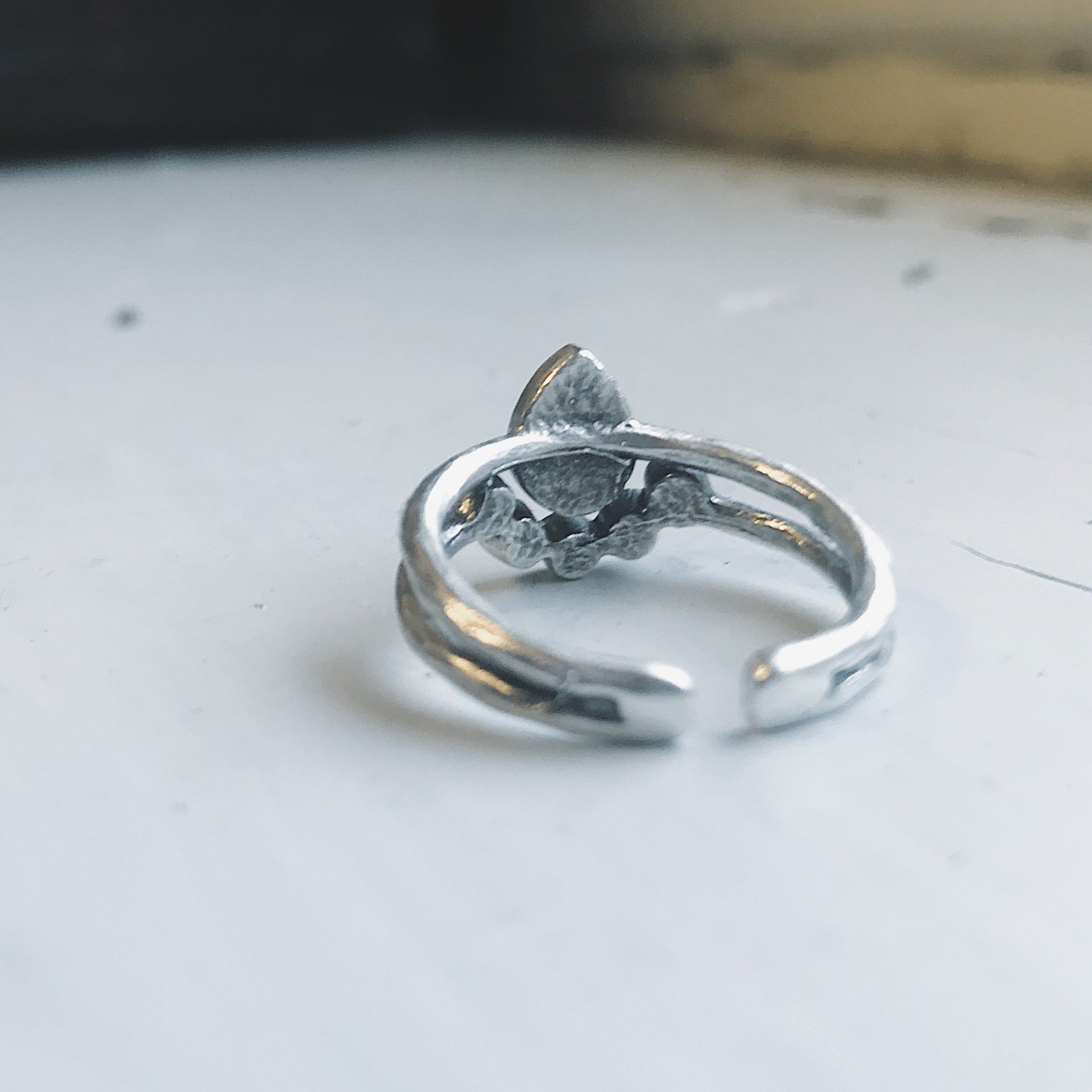 Moondrop Moonstone Ring featuring a teardrop rainbow Moonstone in a bezel surrounded by beads, available in silver and gold tone.