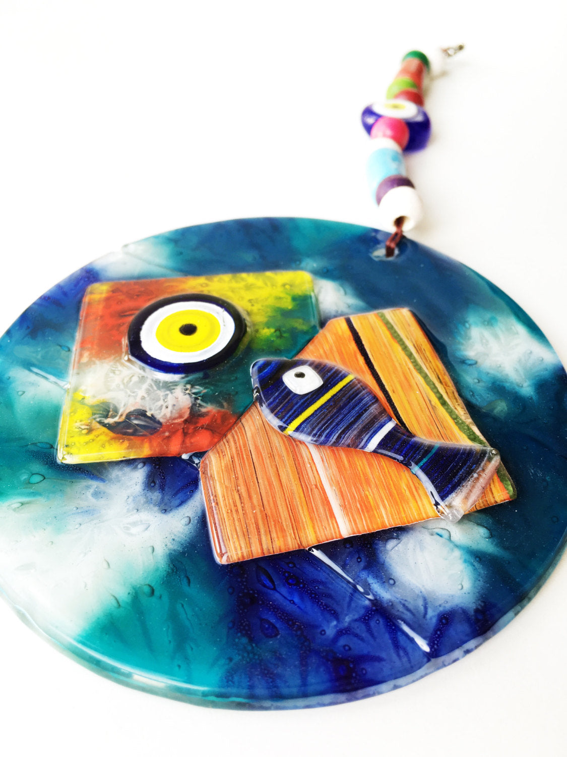 Handmade Mosaic Glass Evil Eye Wall Hanging featuring a vibrant fish design, symbolizing protection and good luck.