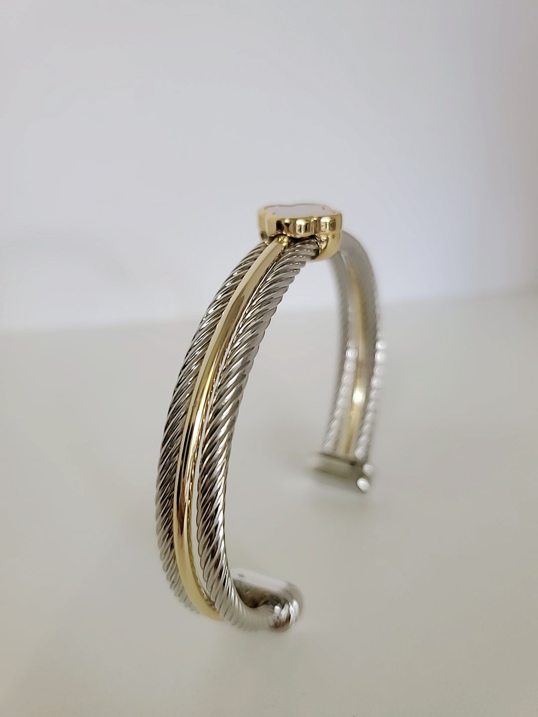 Elegant Mother of Pearl bangle bracelet with 18K Gold Filled clover pattern, showcasing a delicate cable design.