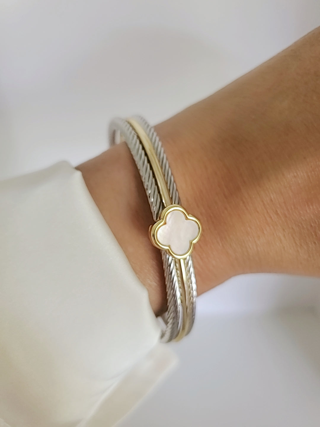 Elegant Mother of Pearl bangle bracelet with 18K Gold Filled clover pattern, showcasing a delicate cable design.