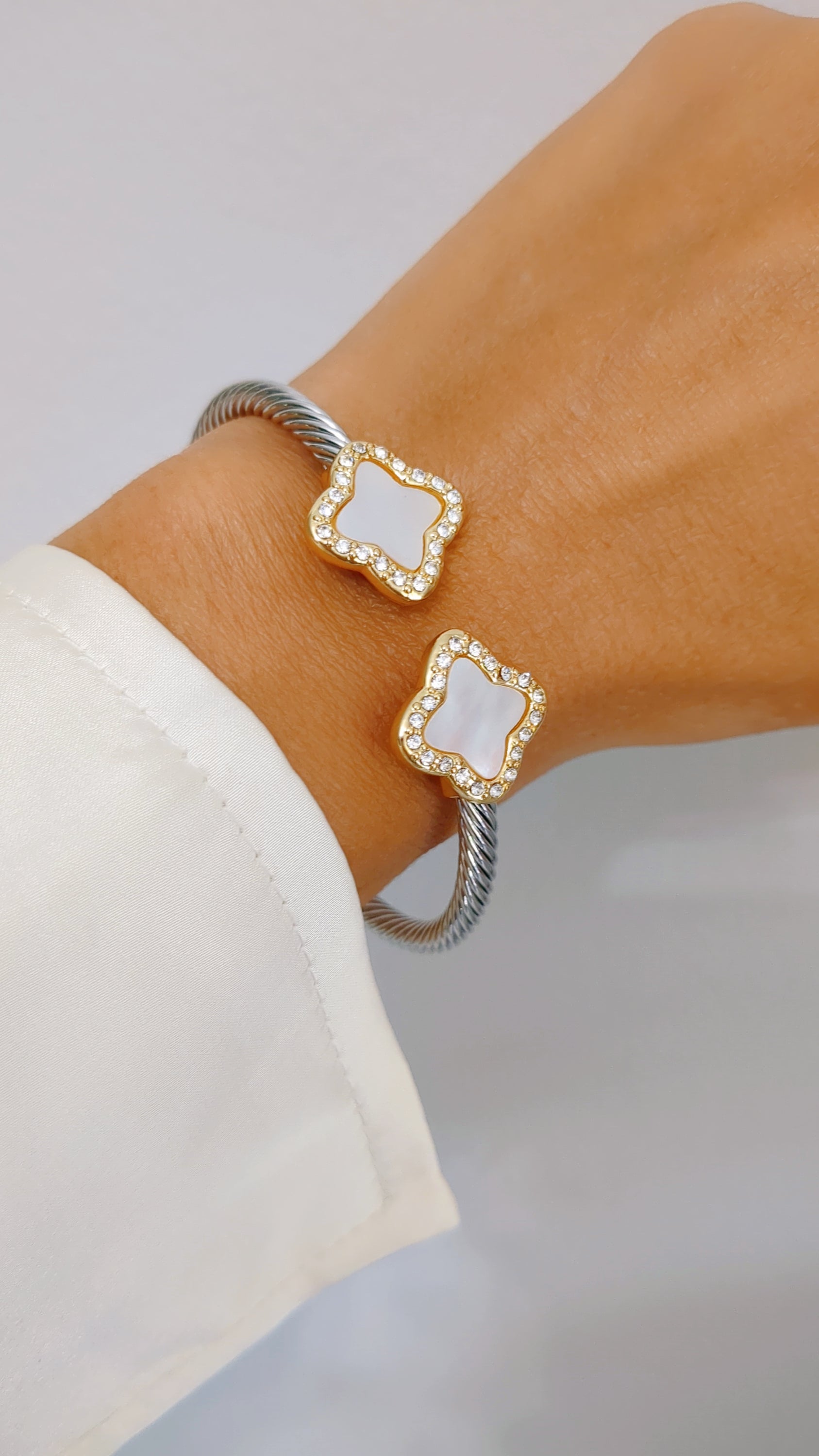 A stylish Mother of Pearl Clover Bangle Bracelet featuring a clover design, crafted from stainless steel with a gold plated finish.