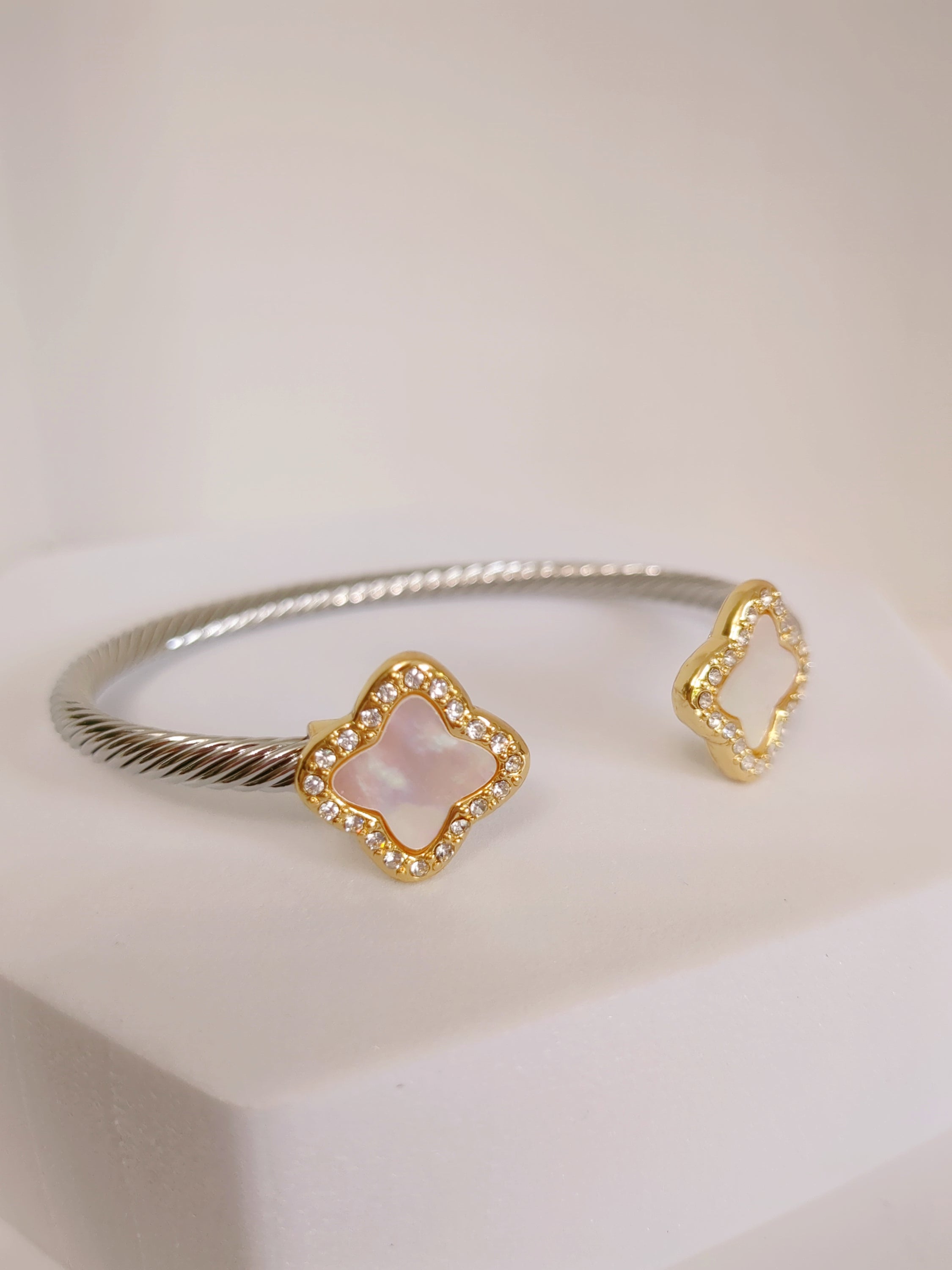 A stylish Mother of Pearl Clover Bangle Bracelet featuring a clover design, crafted from stainless steel with a gold plated finish.