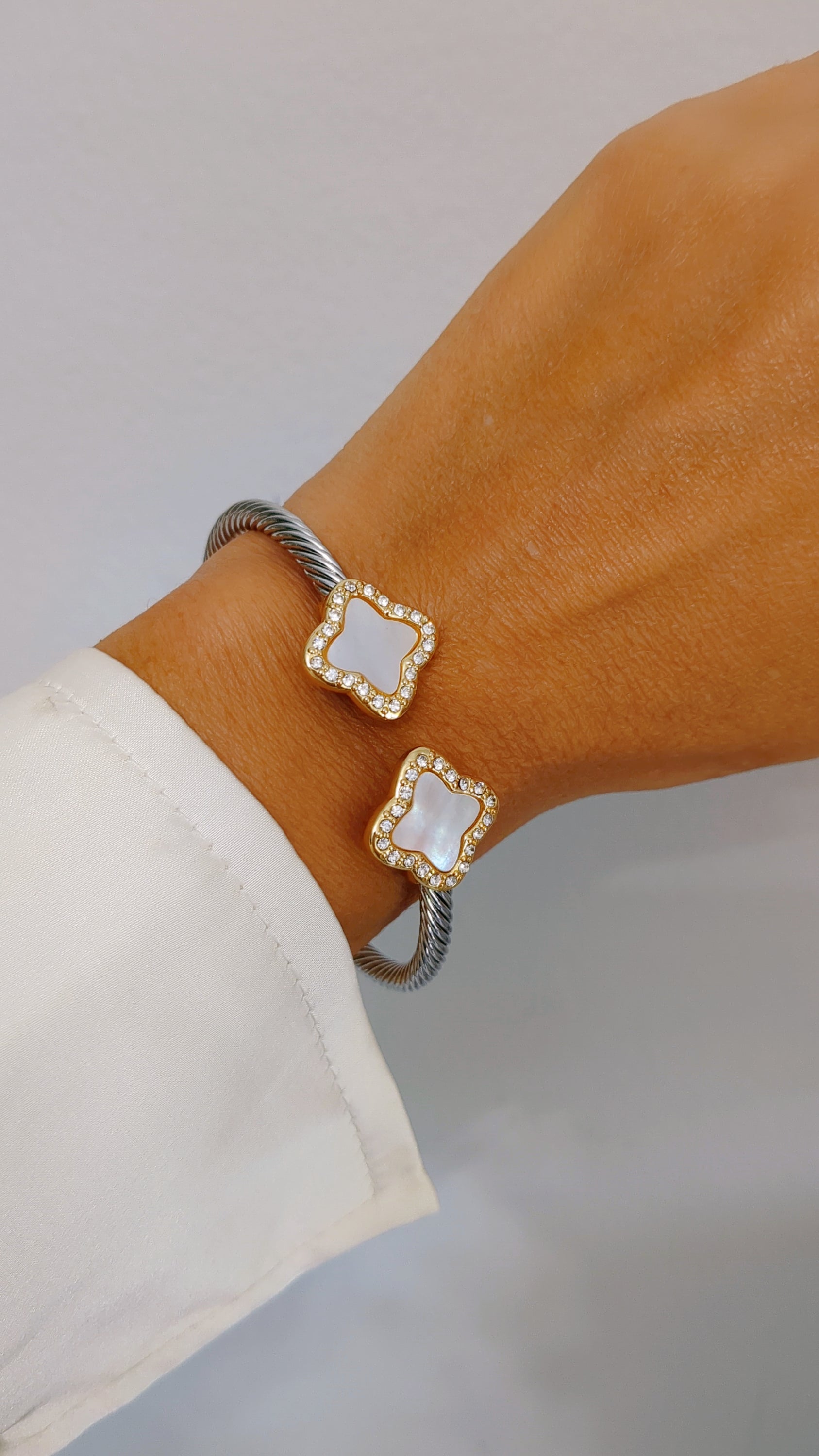 A stylish Mother of Pearl Clover Bangle Bracelet featuring a clover design, crafted from stainless steel with a gold plated finish.