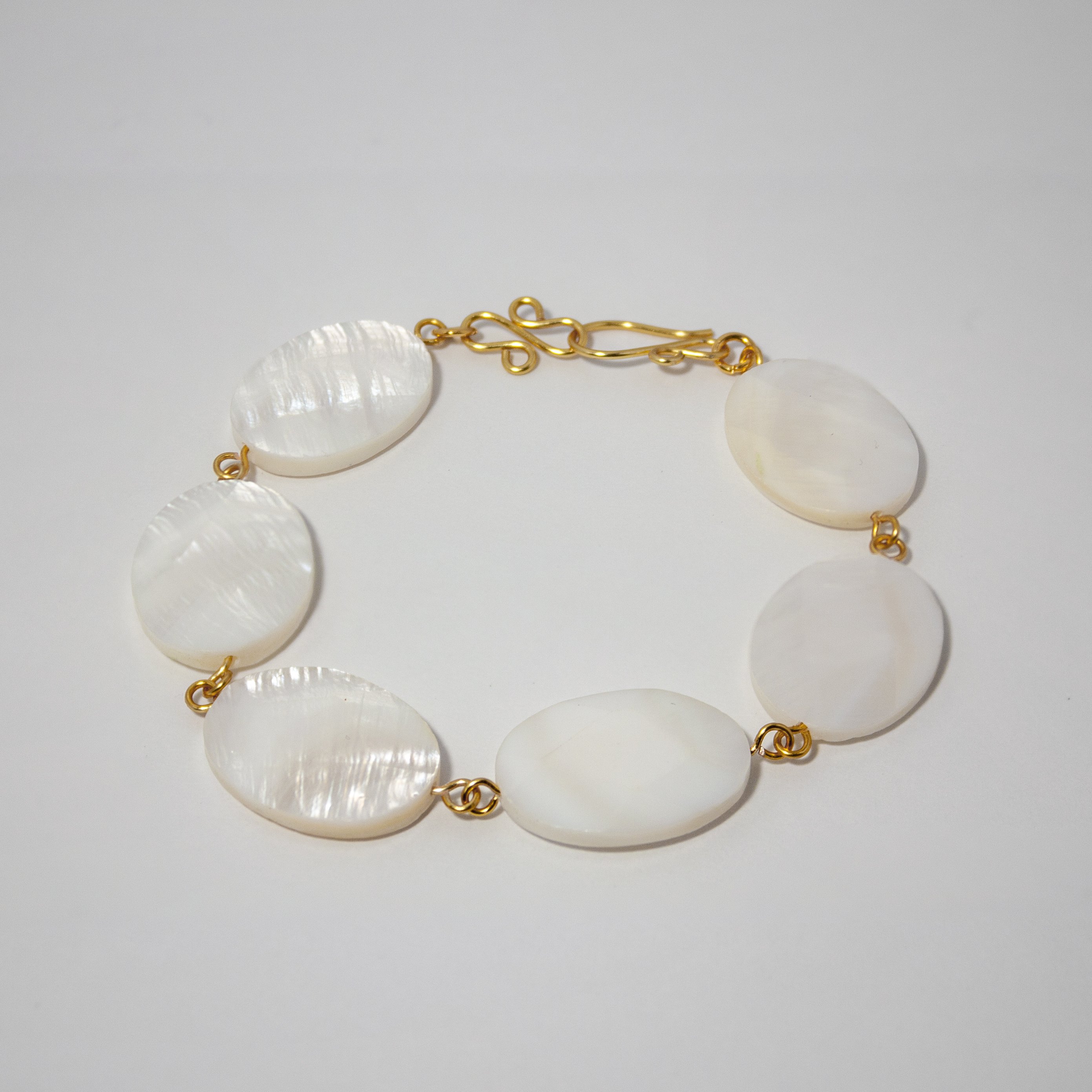 Elegant Mother of Pearl Oval Chain Bracelet featuring natural oval beads and silver-plated copper closure.