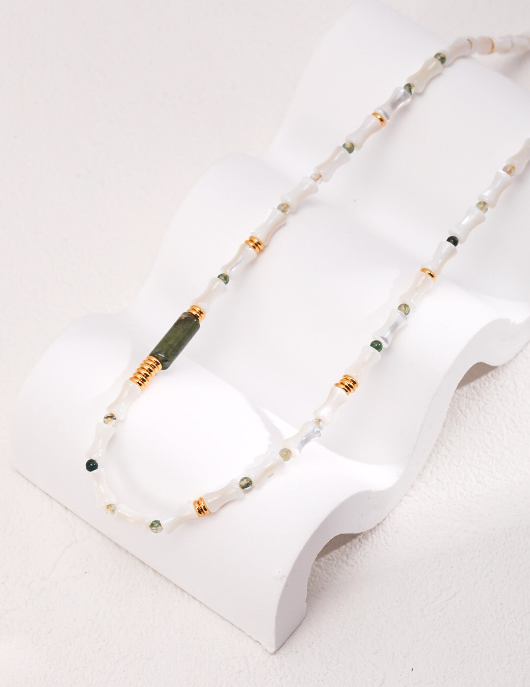 A beautifully handcrafted Mother-of-pearl Bamboo Beaded Necklace featuring aquatic agate beads and gold vermeil accents, elegantly displayed.