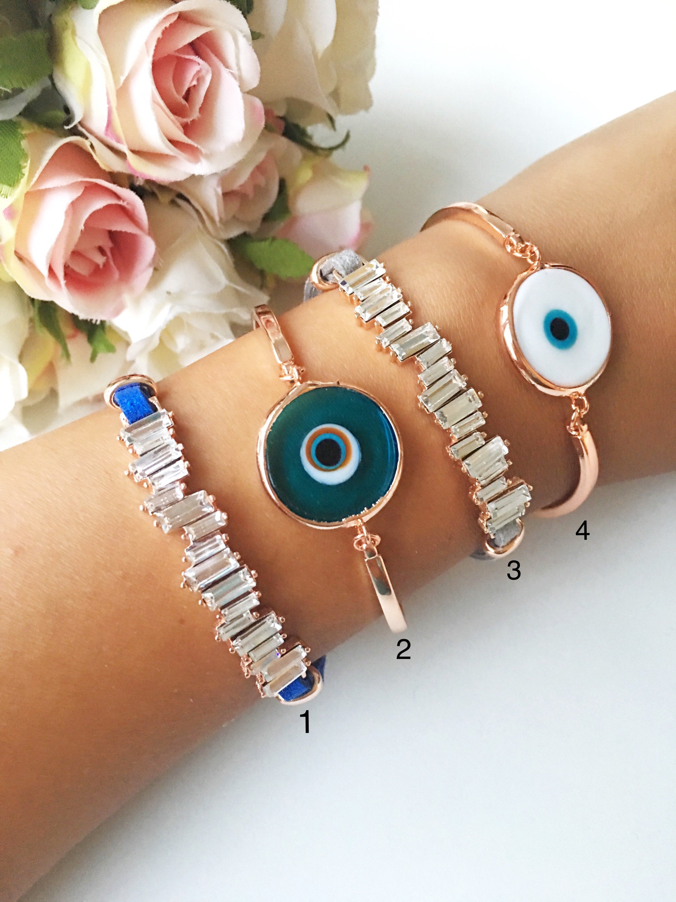 Murano Evil Eye Bracelet featuring a blue evil eye bead, adjustable design, and durable stainless steel material, displayed on a soft background.