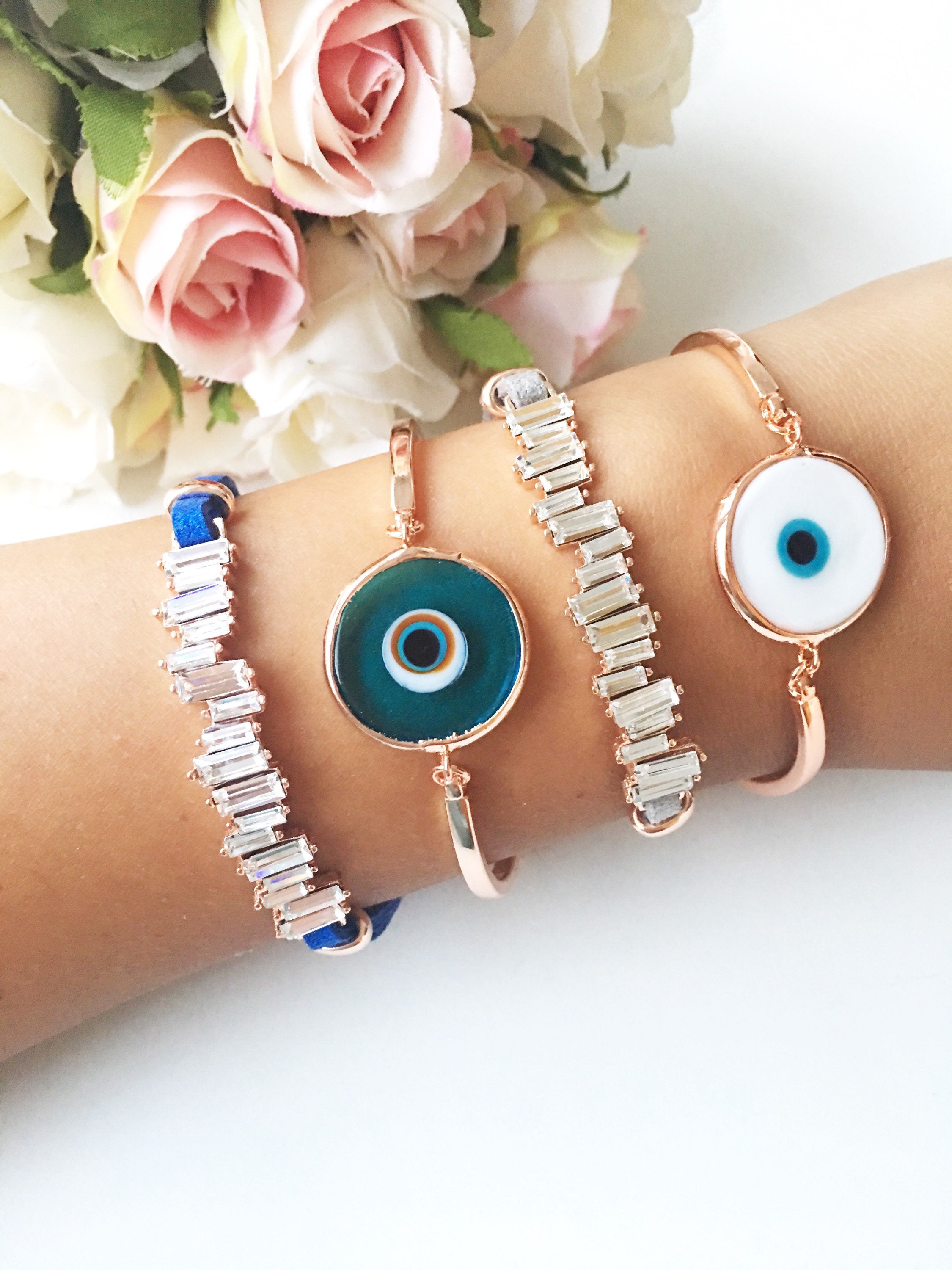 Murano Evil Eye Bracelet featuring a blue evil eye bead, adjustable design, and durable stainless steel material, displayed on a soft background.