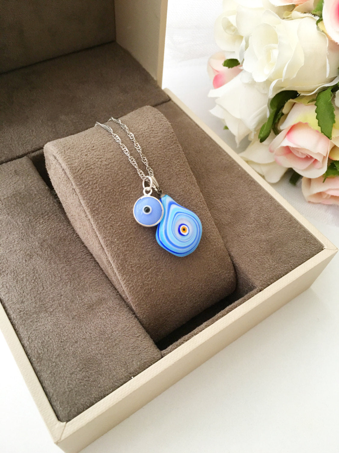 A beautiful Murano glass evil eye necklace featuring a large blue evil eye bead and tiny turquoise and white beads, symbolizing protection and good luck.