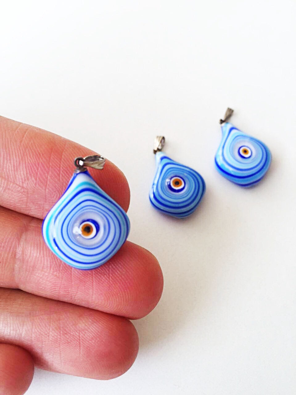 A beautiful Murano glass evil eye pendant featuring a vibrant blue lampwork bead, symbolizing protection and good luck.